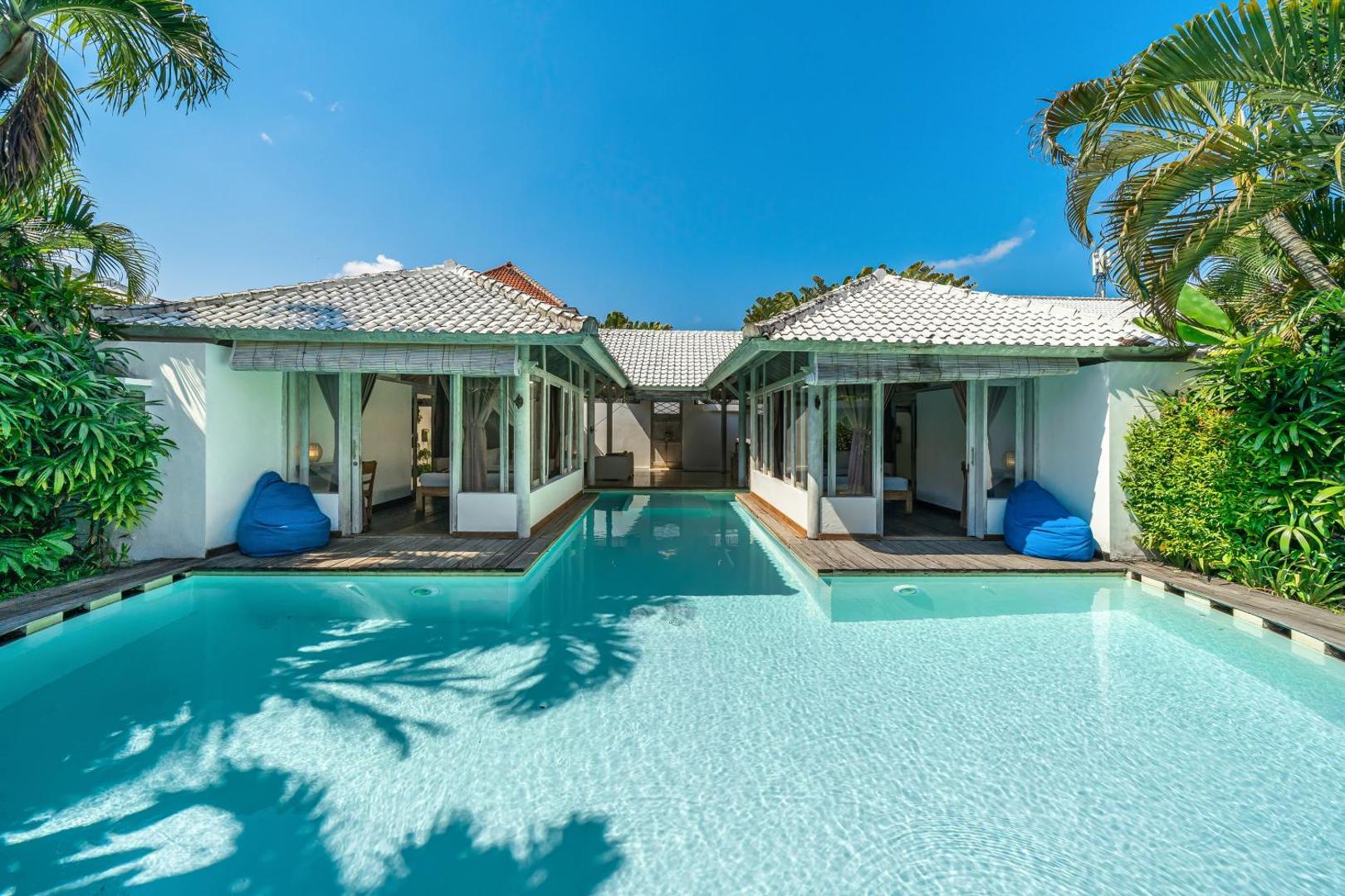 The pool at Villa Laksmana Hideaway 2 running between two whitewashed bedroom pavilions