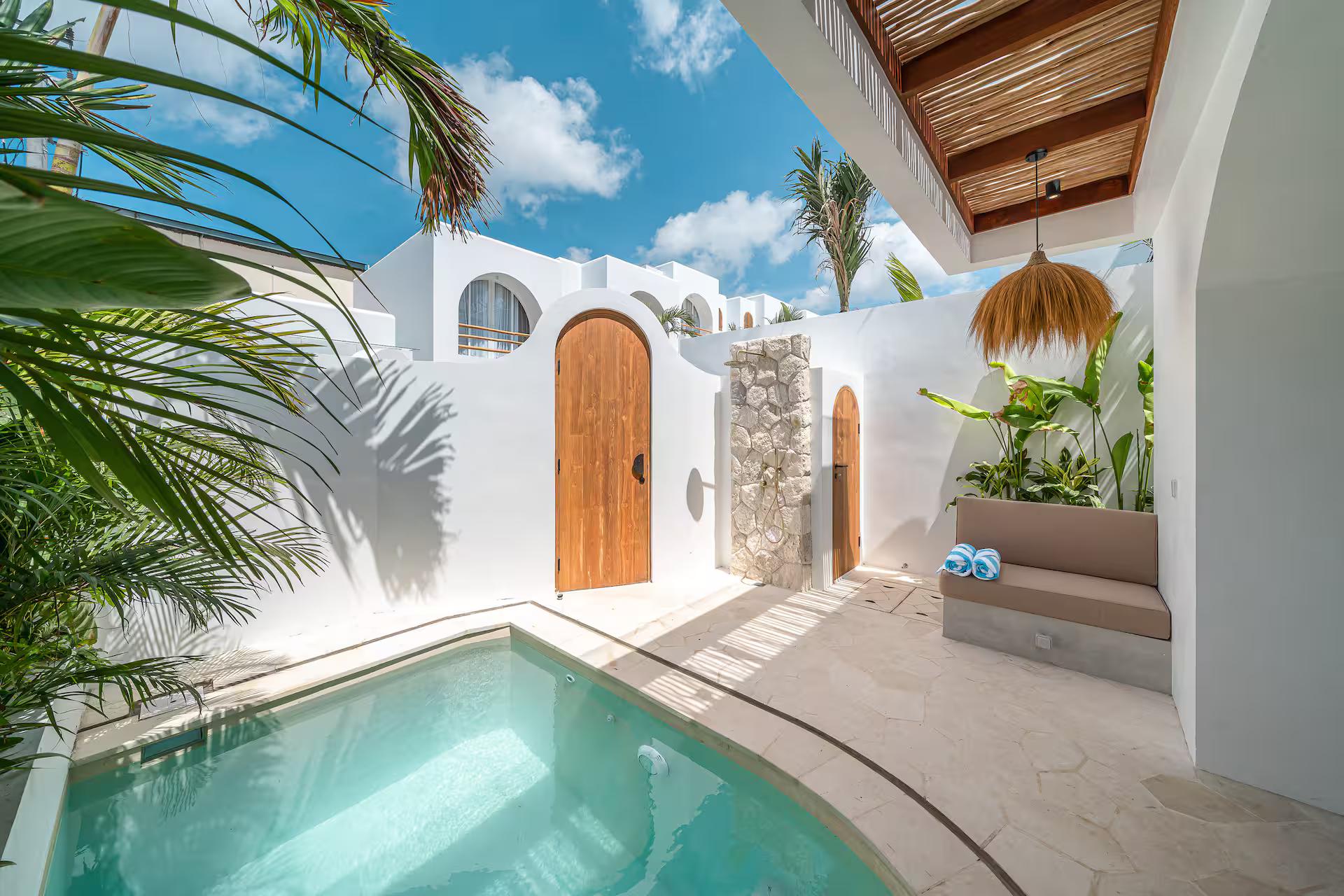 The pool at Las Casas 17, arched timber door and a timber-lined overhang above the terrace