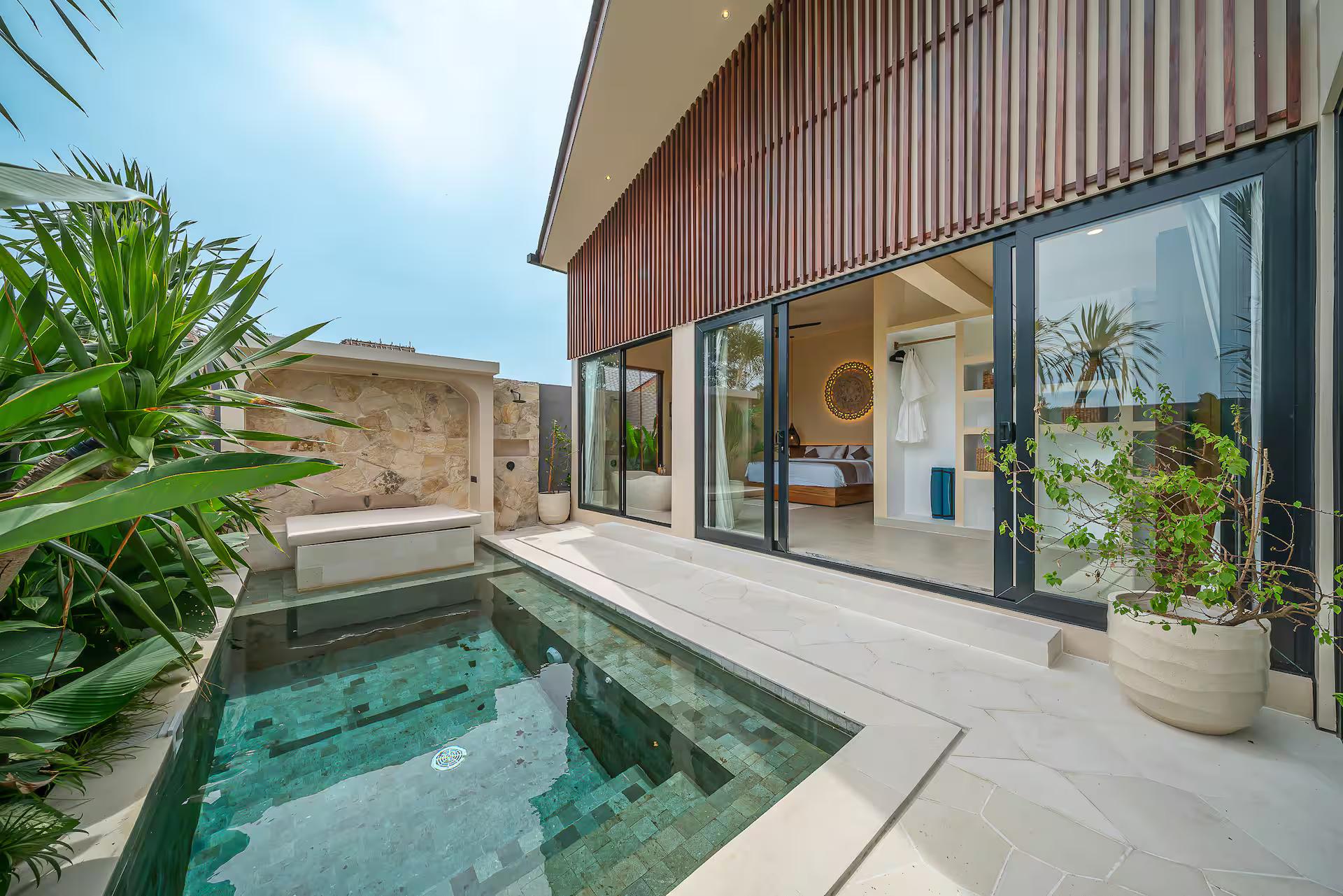 The green-tiled pool at Villa Seabel below an upper storey clad in red-brown timber battens