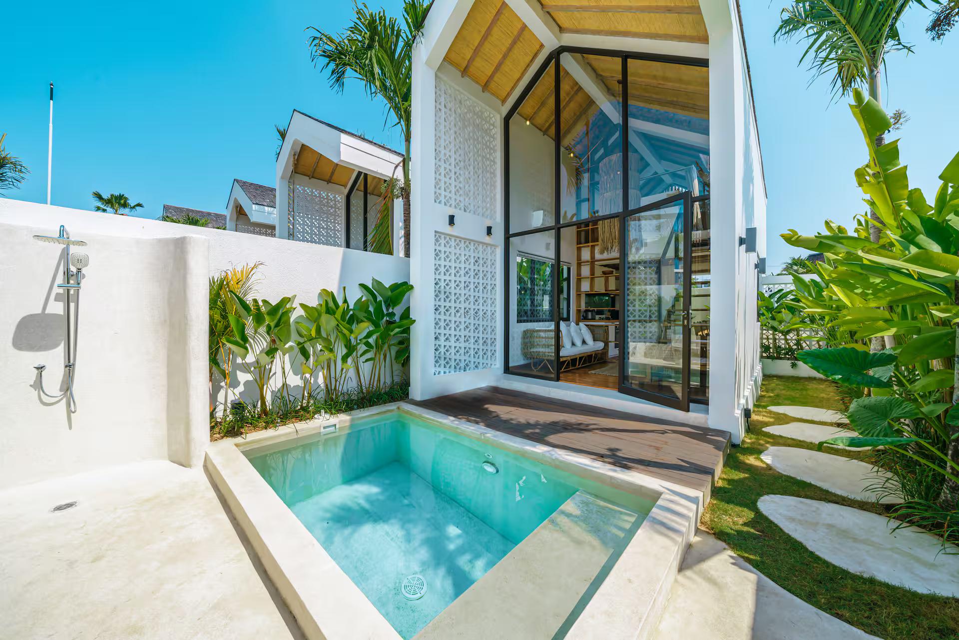 The plunge pool and glazed gable end of Villa Tiny, an A-frame in white render