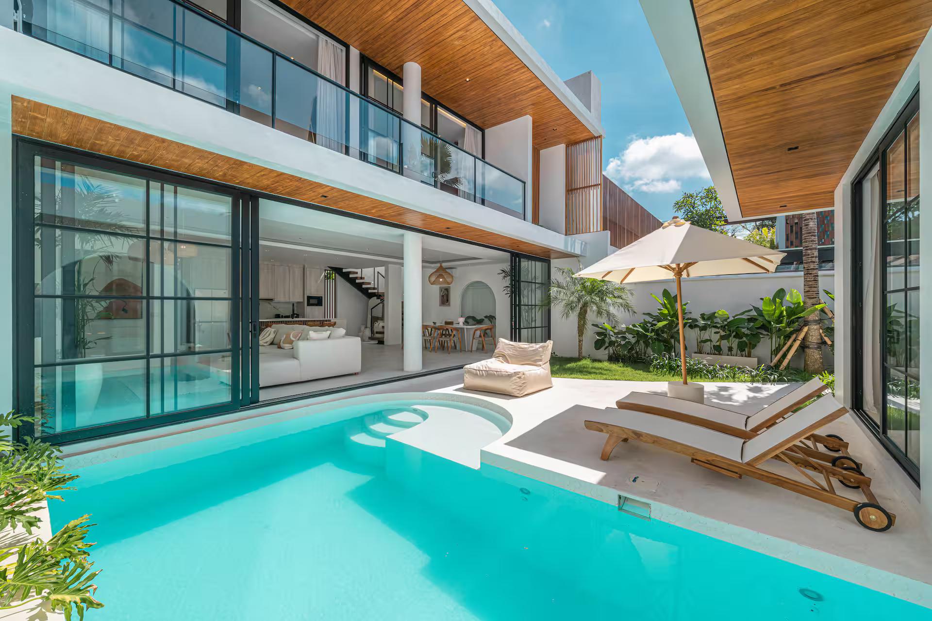 The pool at Villa Jenna below the upper floor, timber-battened soffit shading the terrace