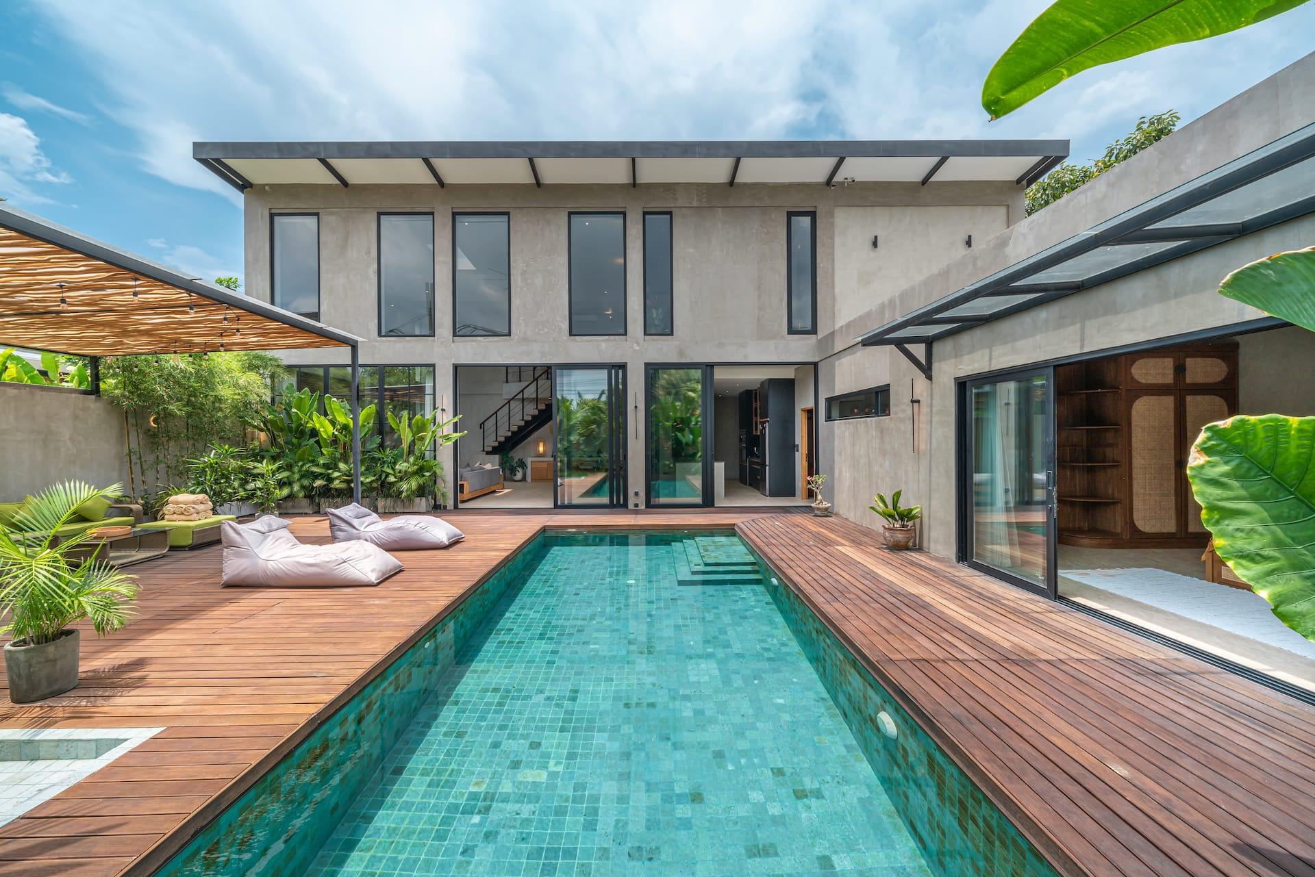 Villa Zenloft's green-tiled pool and hardwood deck in front of the two-storey concrete and glass loft