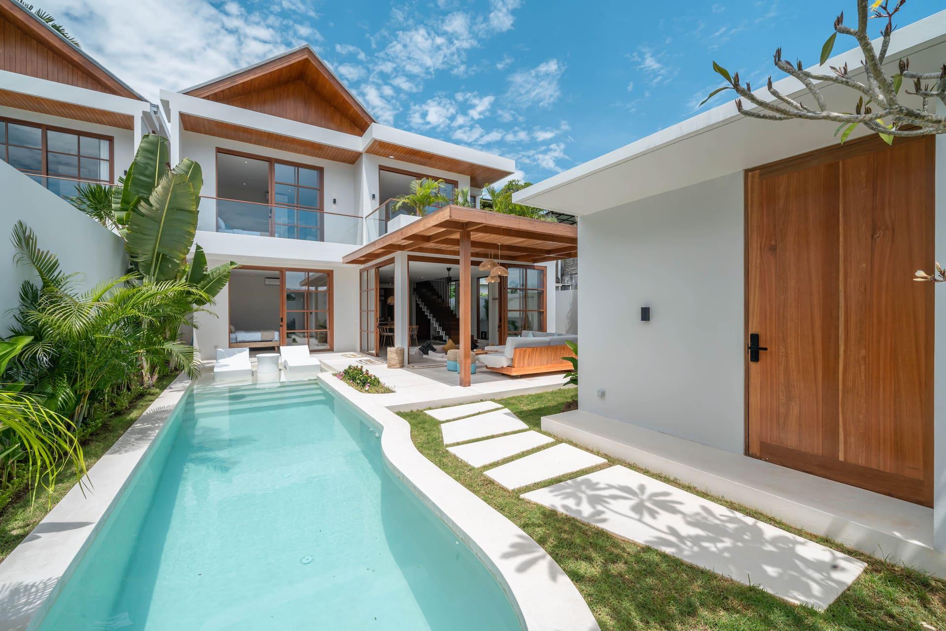 Villa LouLou in Umalas: the long turquoise pool runs between the two-storey villa and its open timber pavilion