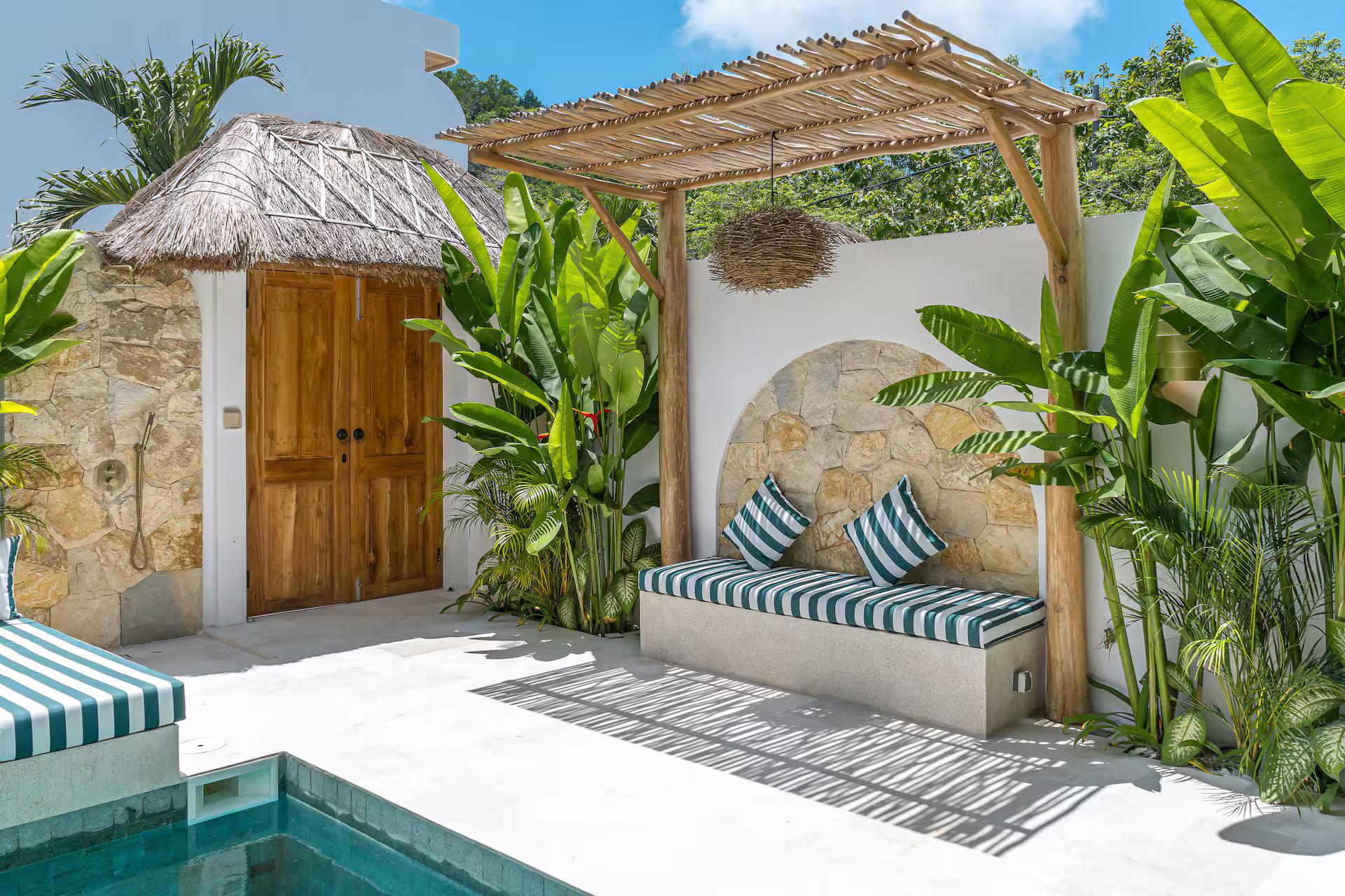 Bamboo pergola and carved timber gate above the built-in bench beside the pool