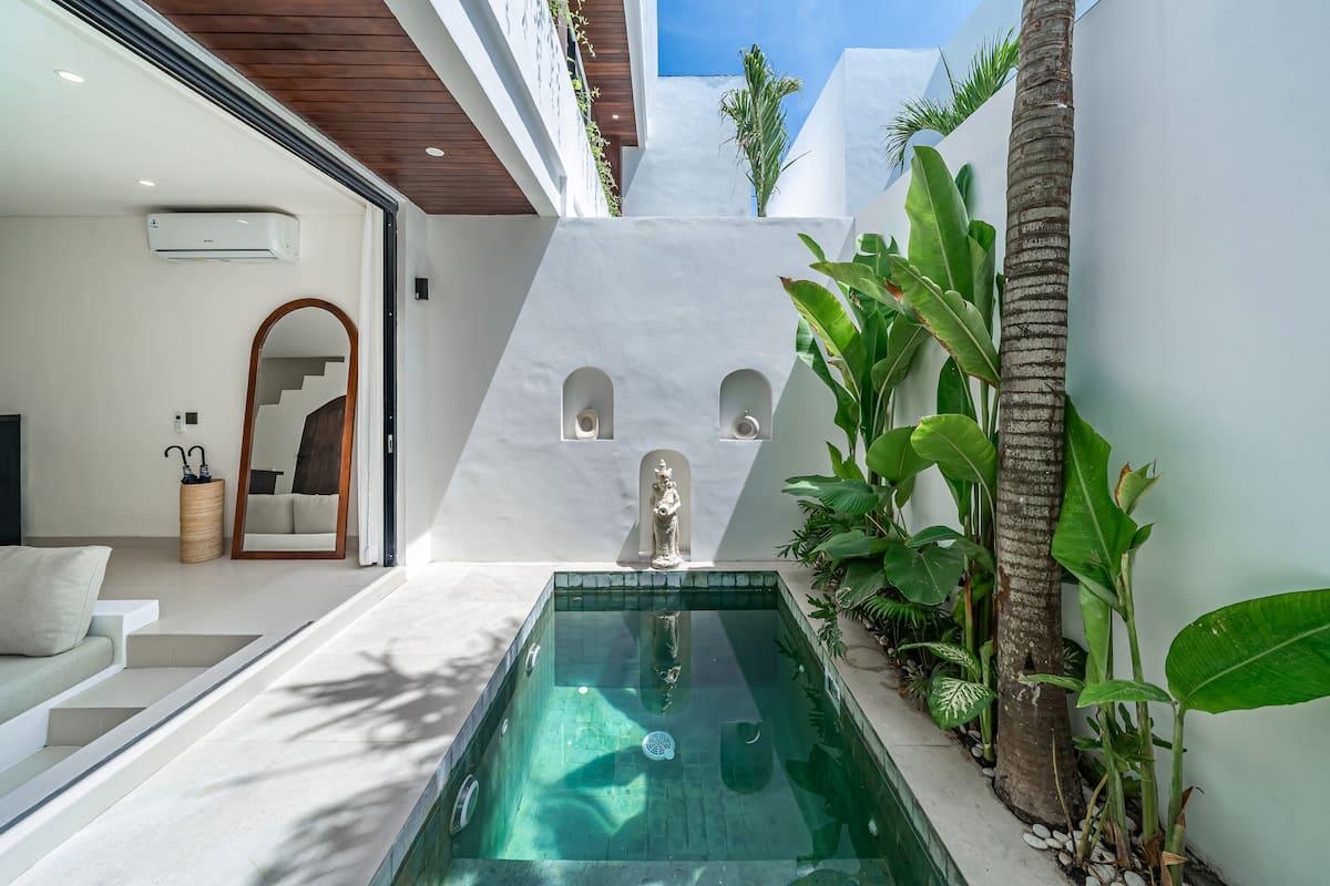 The narrow pool runs the length of the courtyard past a stone deity set in an arched niche