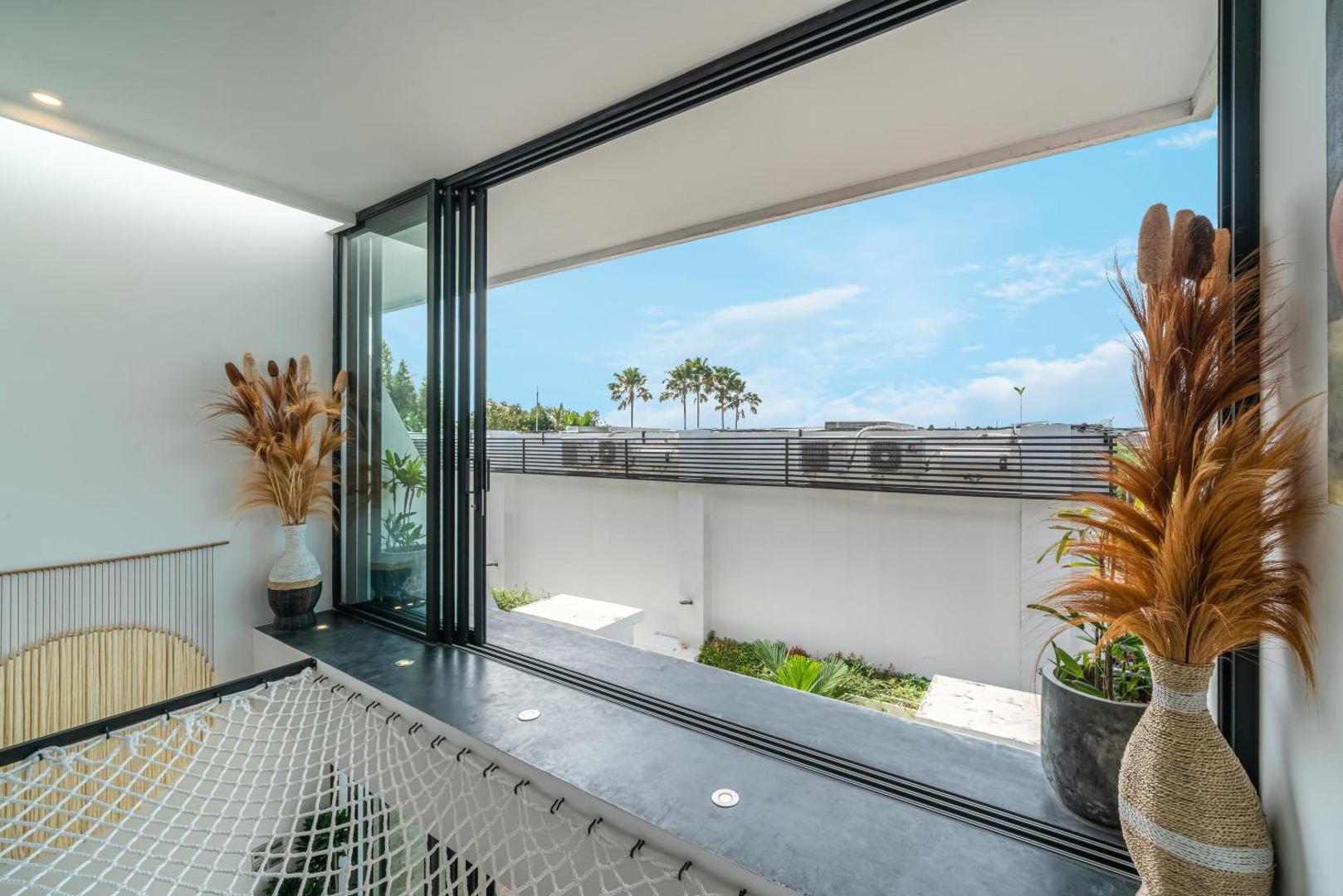Upper terrace with the glazing folded back over a rope hammock net and the rooftops