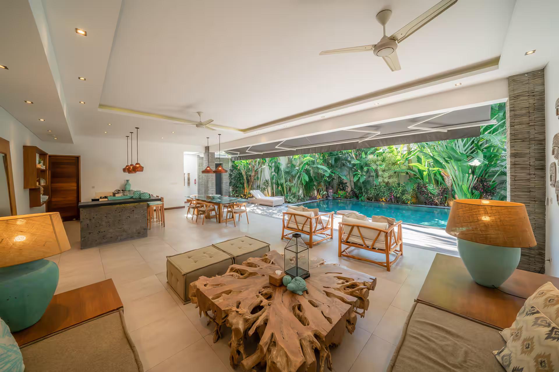 Living pavilion open to the deck, teak-root coffee table and turquoise ceramic lamps