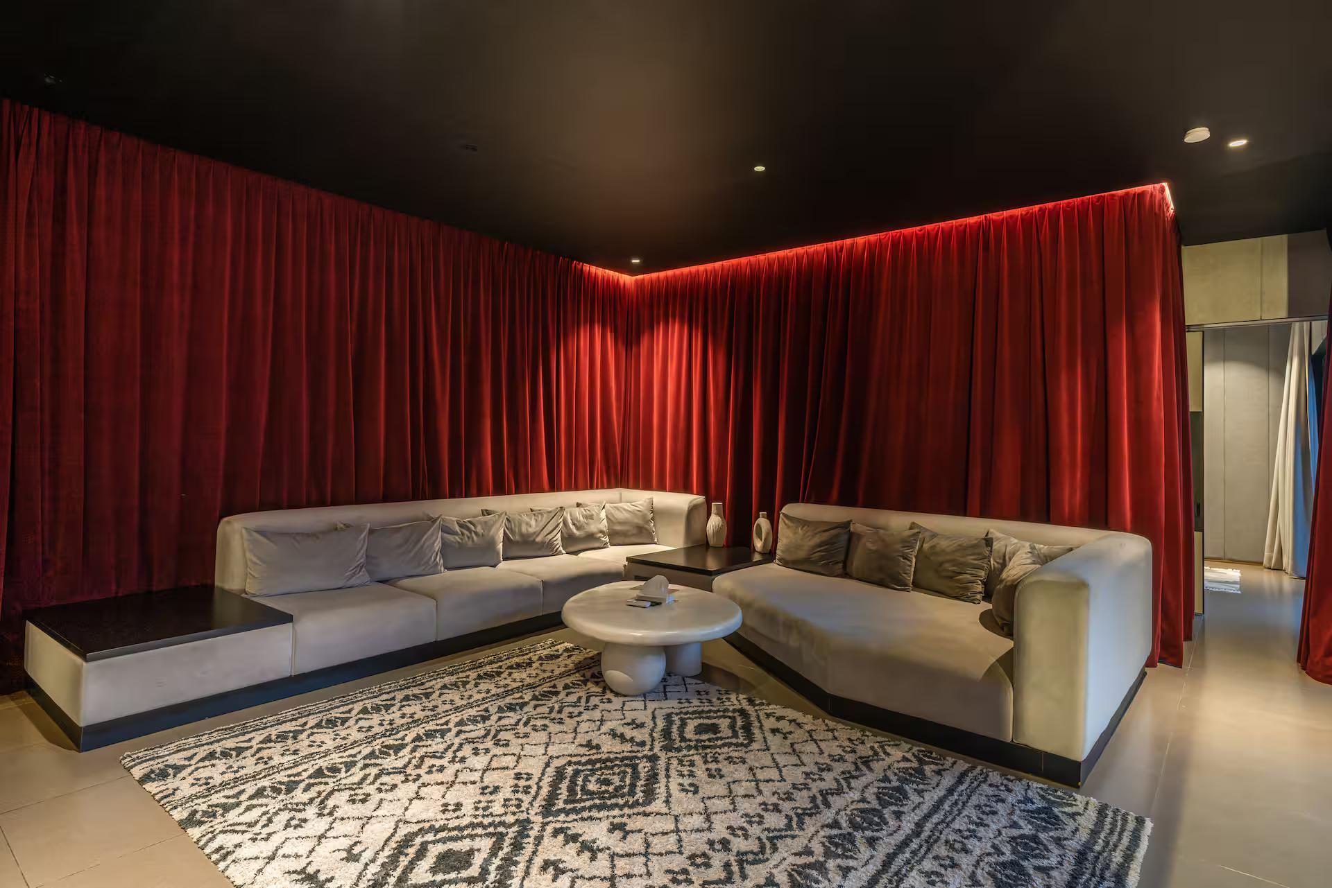 Second-floor living room hung in red velvet curtains around a pale sectional