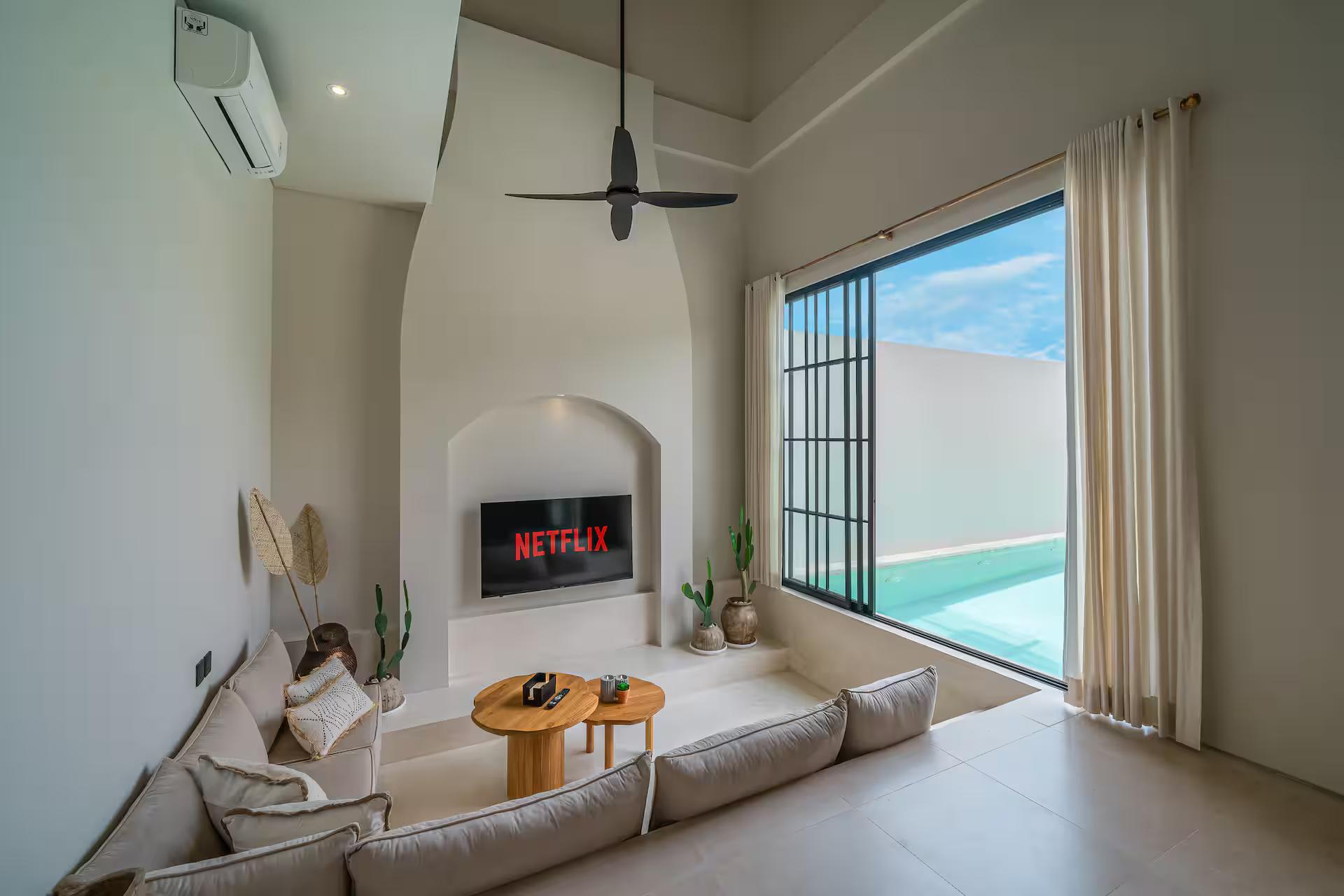 Sunken lounge at Casa 24, pale built-in seating facing a window that fills with pool water