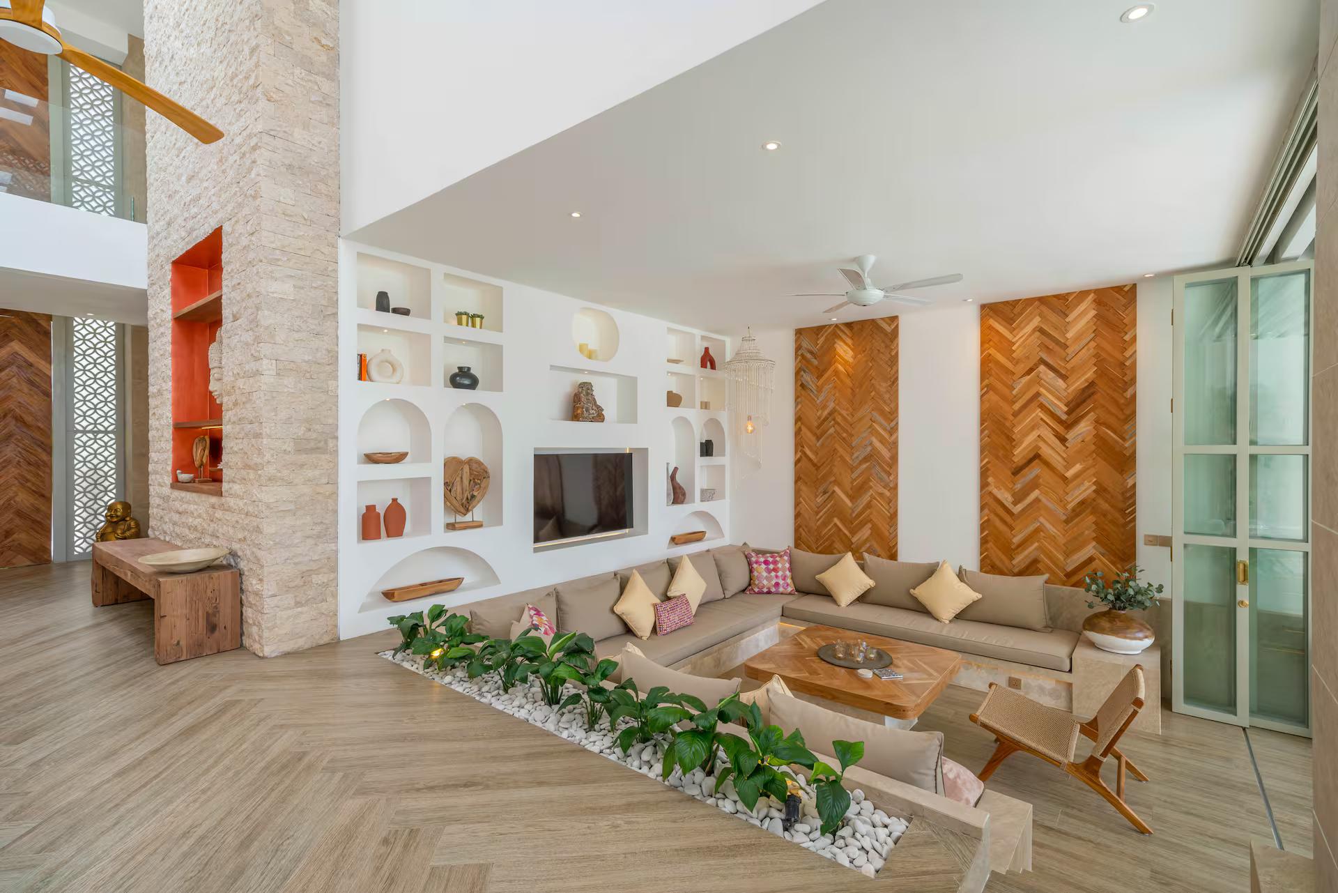 Sunken living room with arched display niches, a low sectional and a wide screen