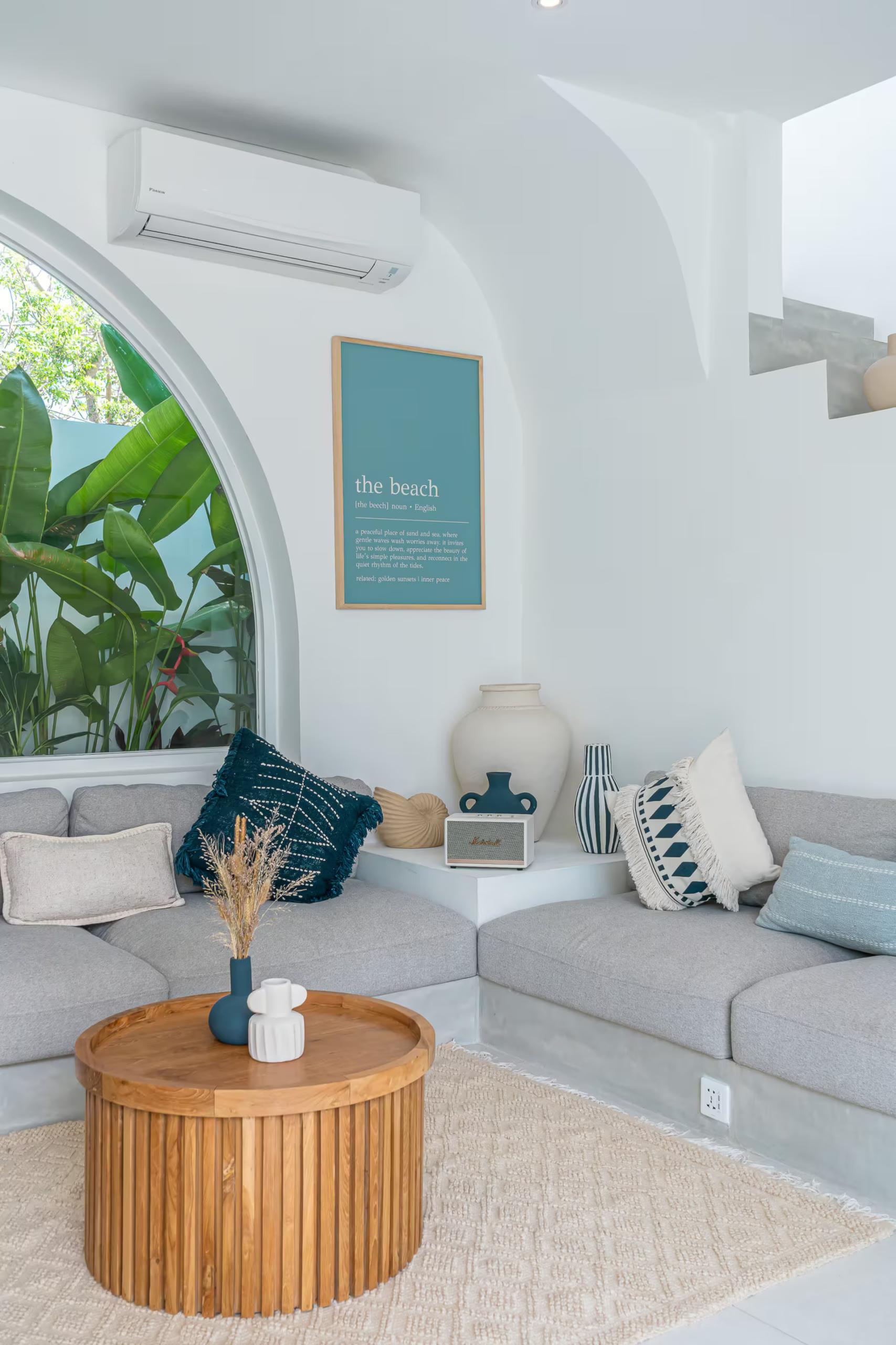 The living room at Villa Solaia, a low built-in sofa under a tall arched window