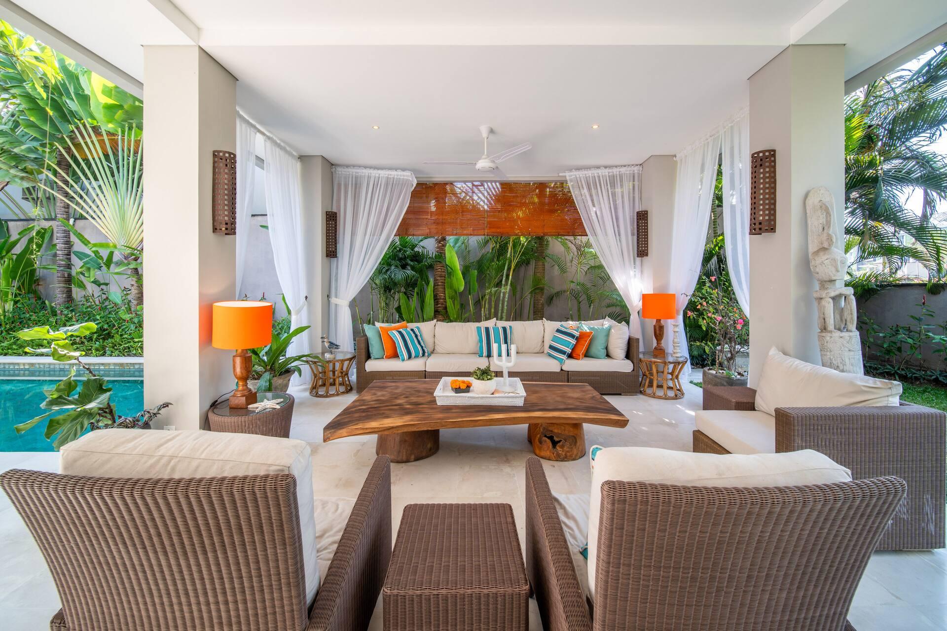 Main living pavilion at Villa Sunsara 2 with orange lamps, deep sofas and garden views on every side