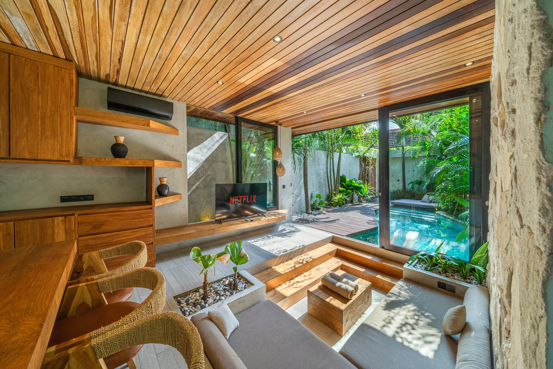 Sunken lounge at Villa Solani under a pitched teak ceiling, open along one side to the pool