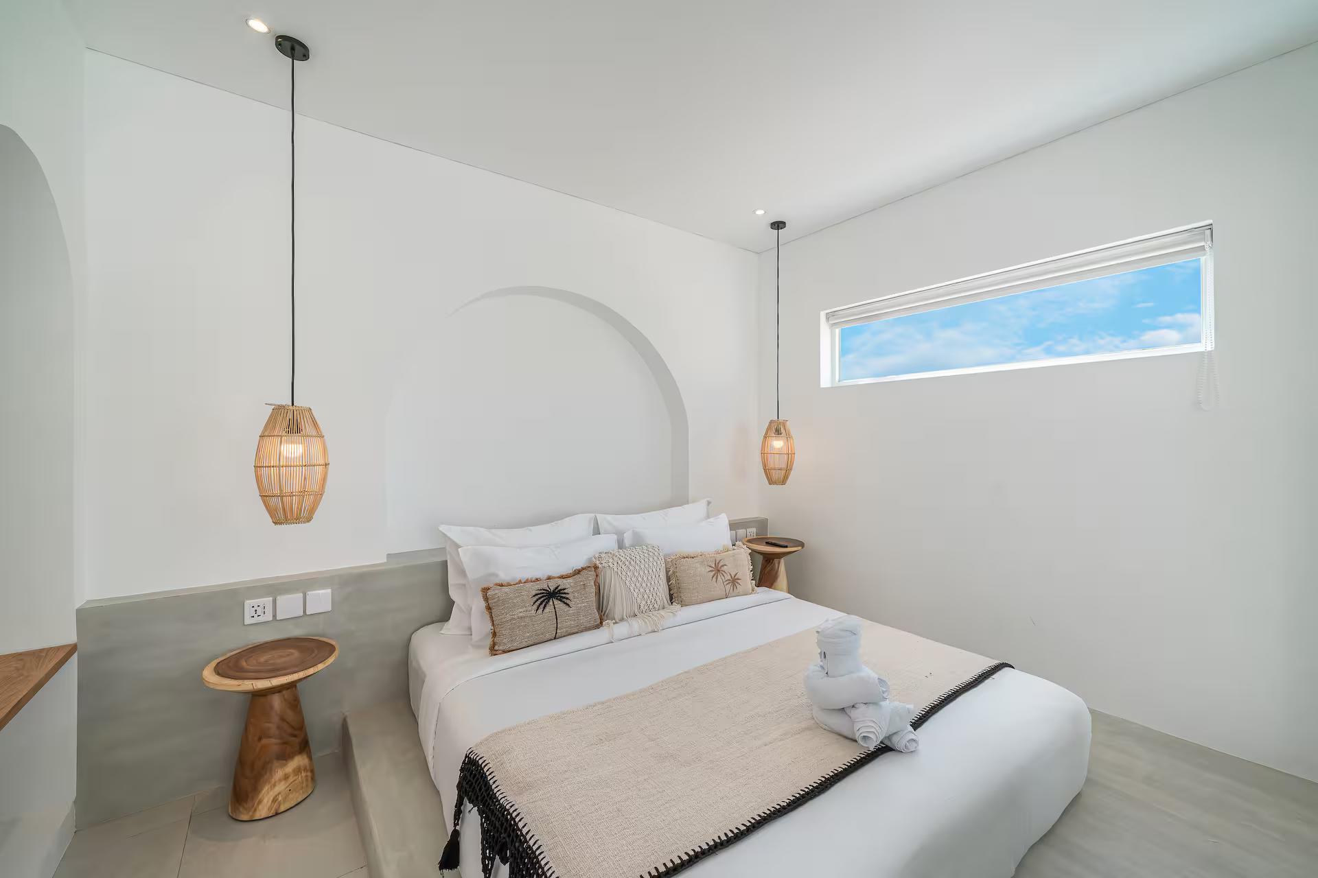 The bedroom with an arched alcove behind the bed and a long clerestory window above