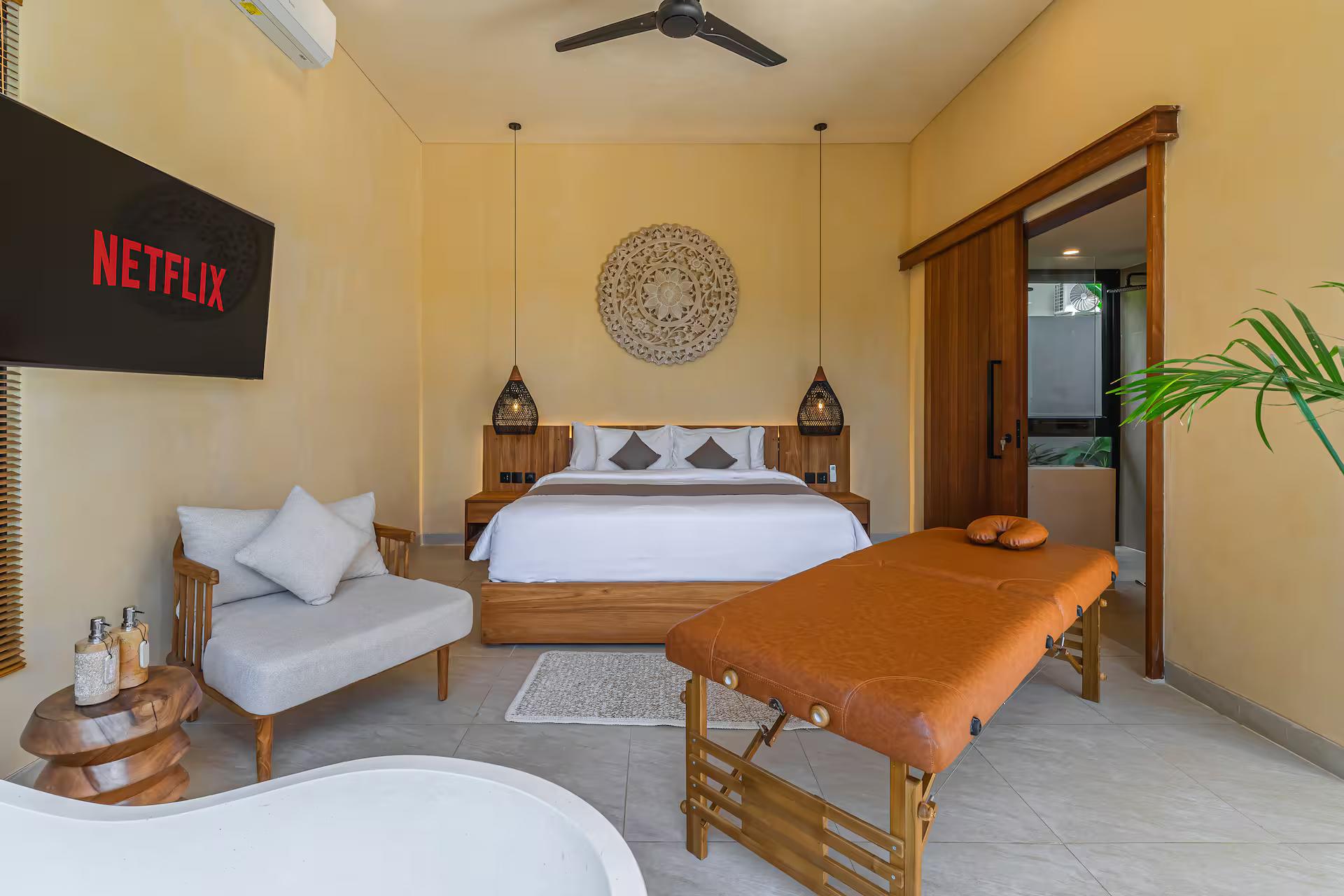 The master bedroom at Villa Seabel with a leather massage table set up beside the king bed