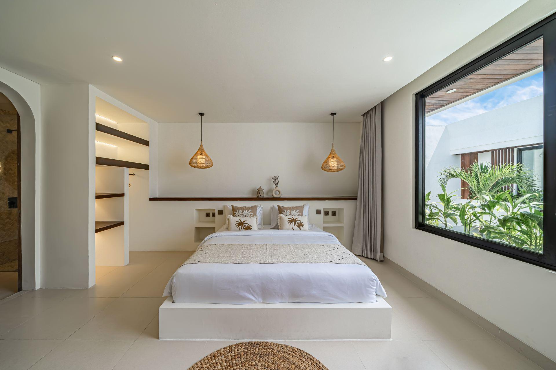 Bedroom at Nova Oasis Berawa 5, a white plaster bed platform beneath a timber ledge shelf