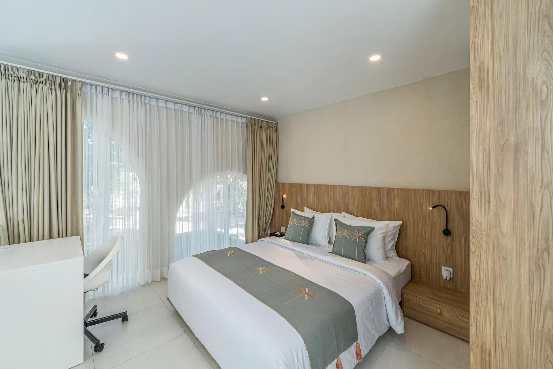Mezzanine bedroom at Bingin Unit 13, desk and chair beside a timber headboard wall