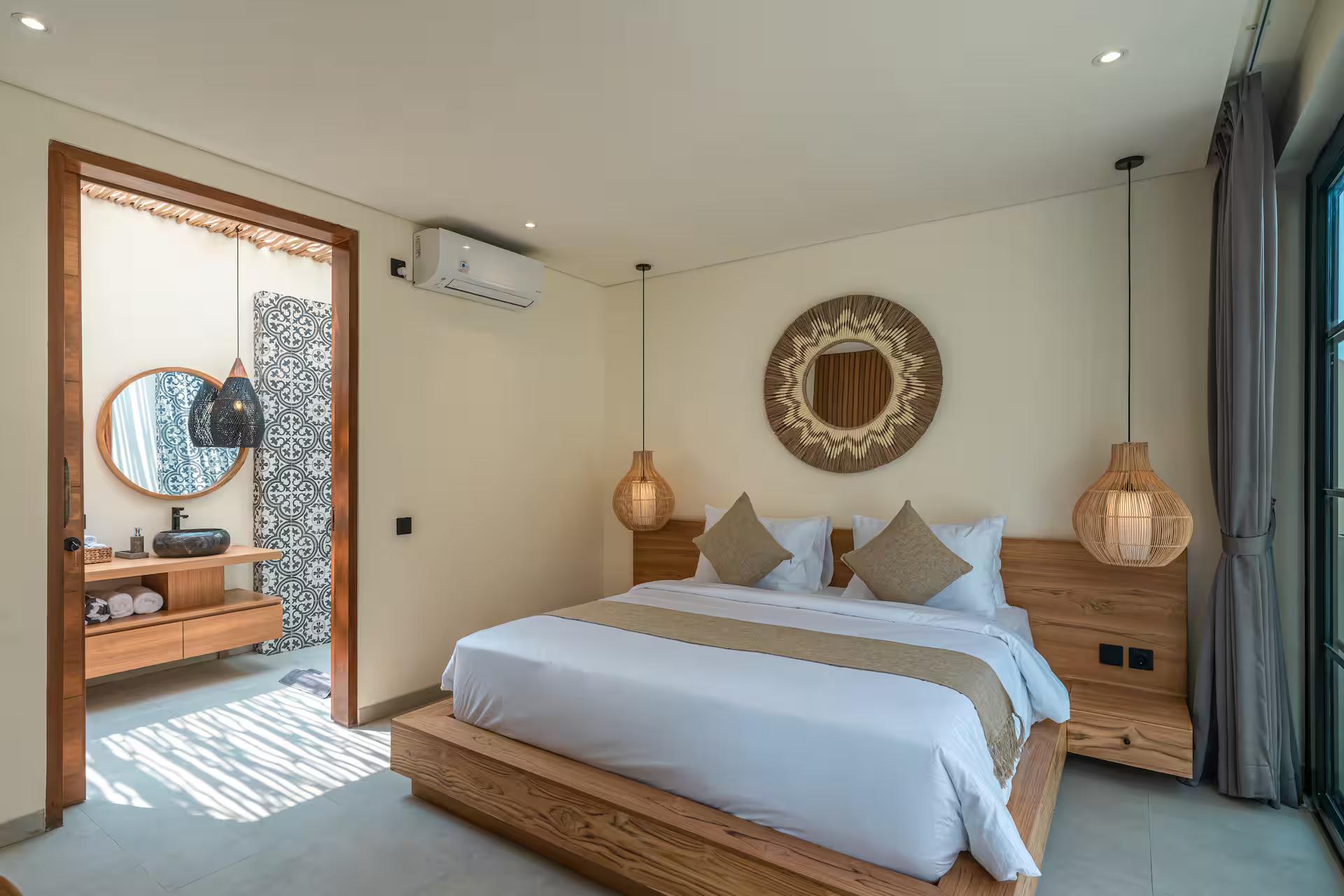 King bedroom at Villa Isly with a round carved mirror and a panel of patterned tile