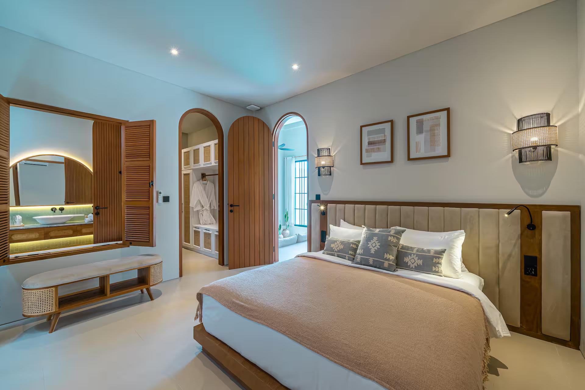 Bedroom with a ribbed timber headboard, a long bench and arched doors to the landing
