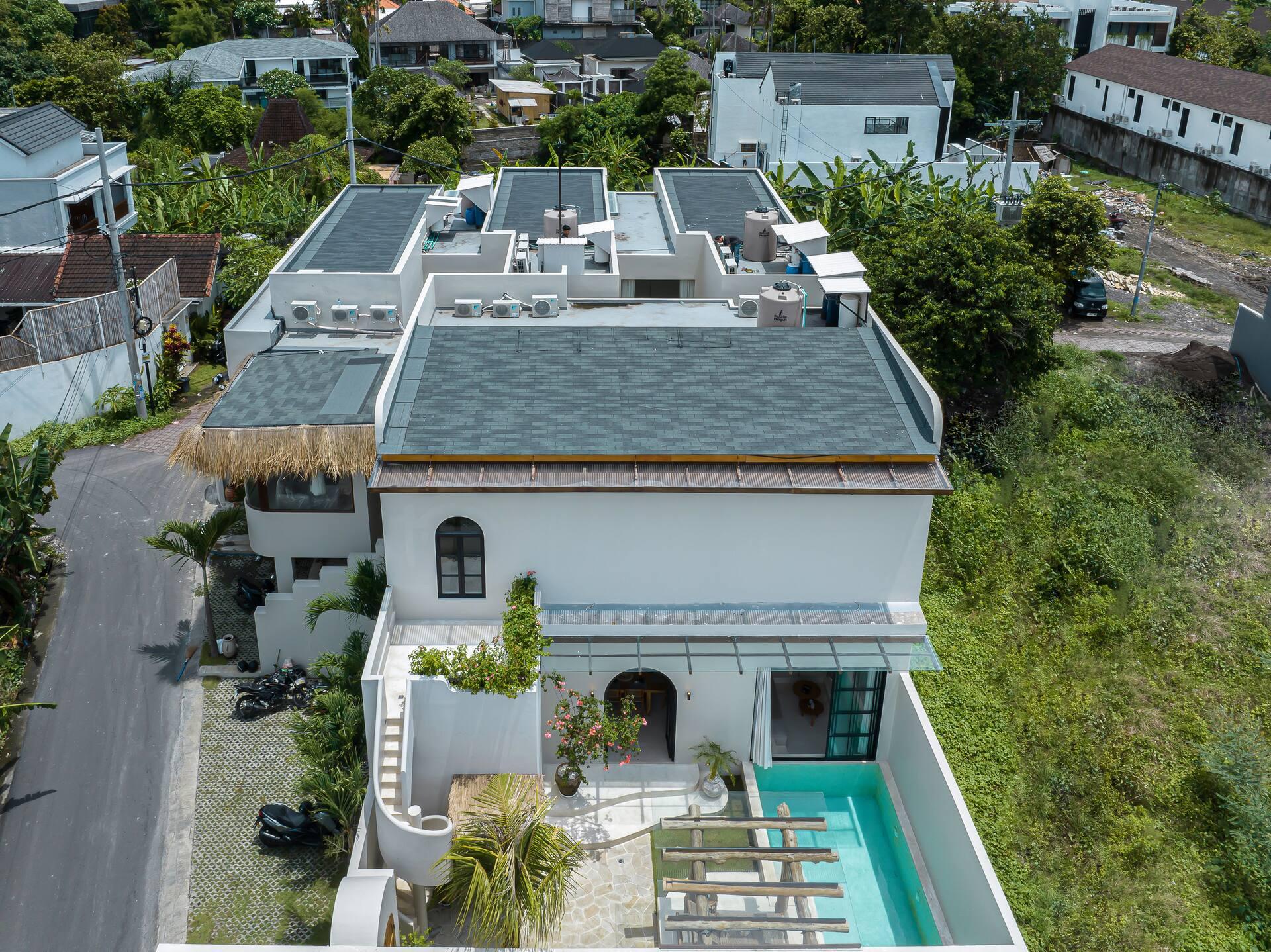The three roofs of Casa 24 side by side above the lane, pool and terraces below
