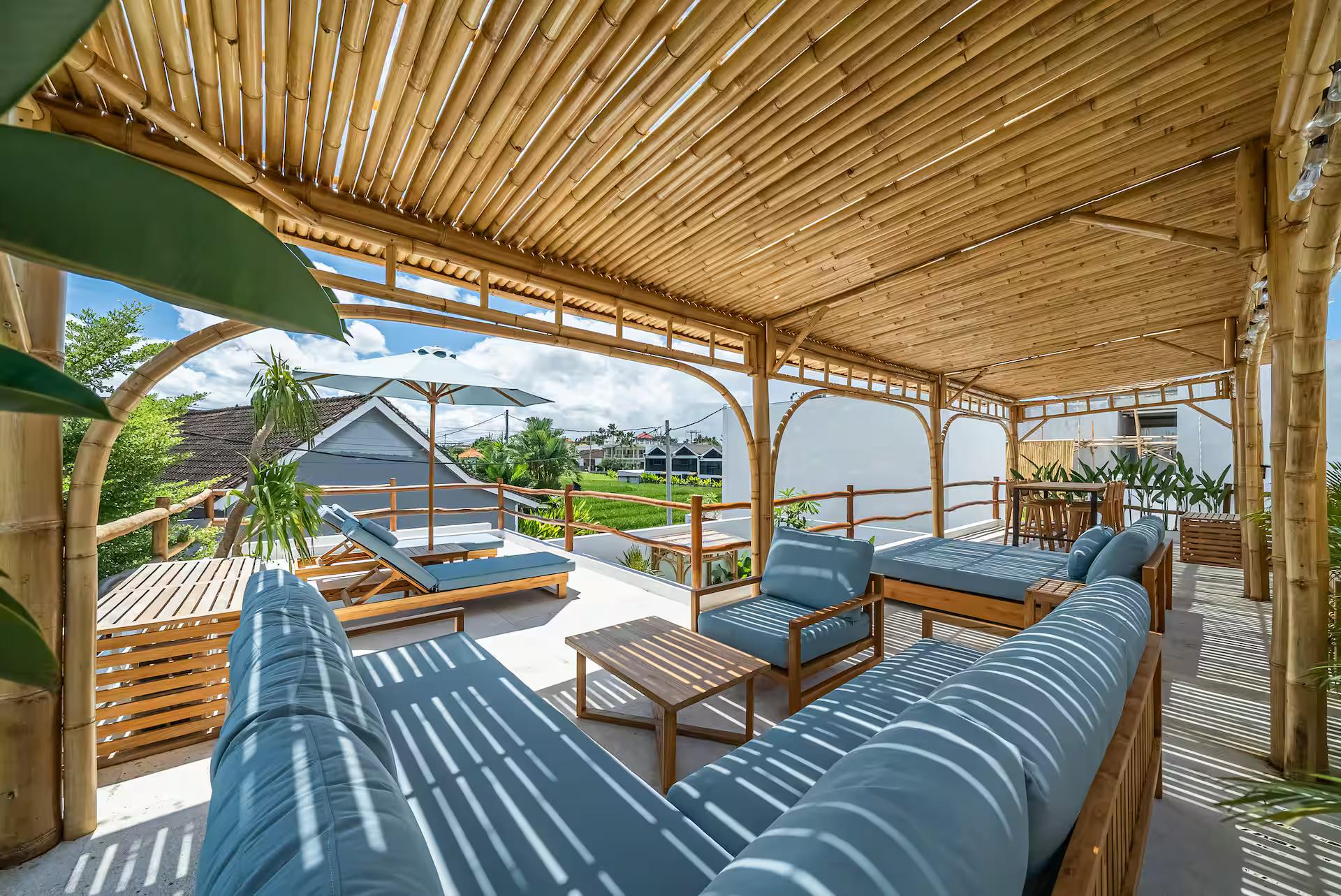 Blue striped sofa and daybed under the woven bamboo ceiling of the rooftop pavilion