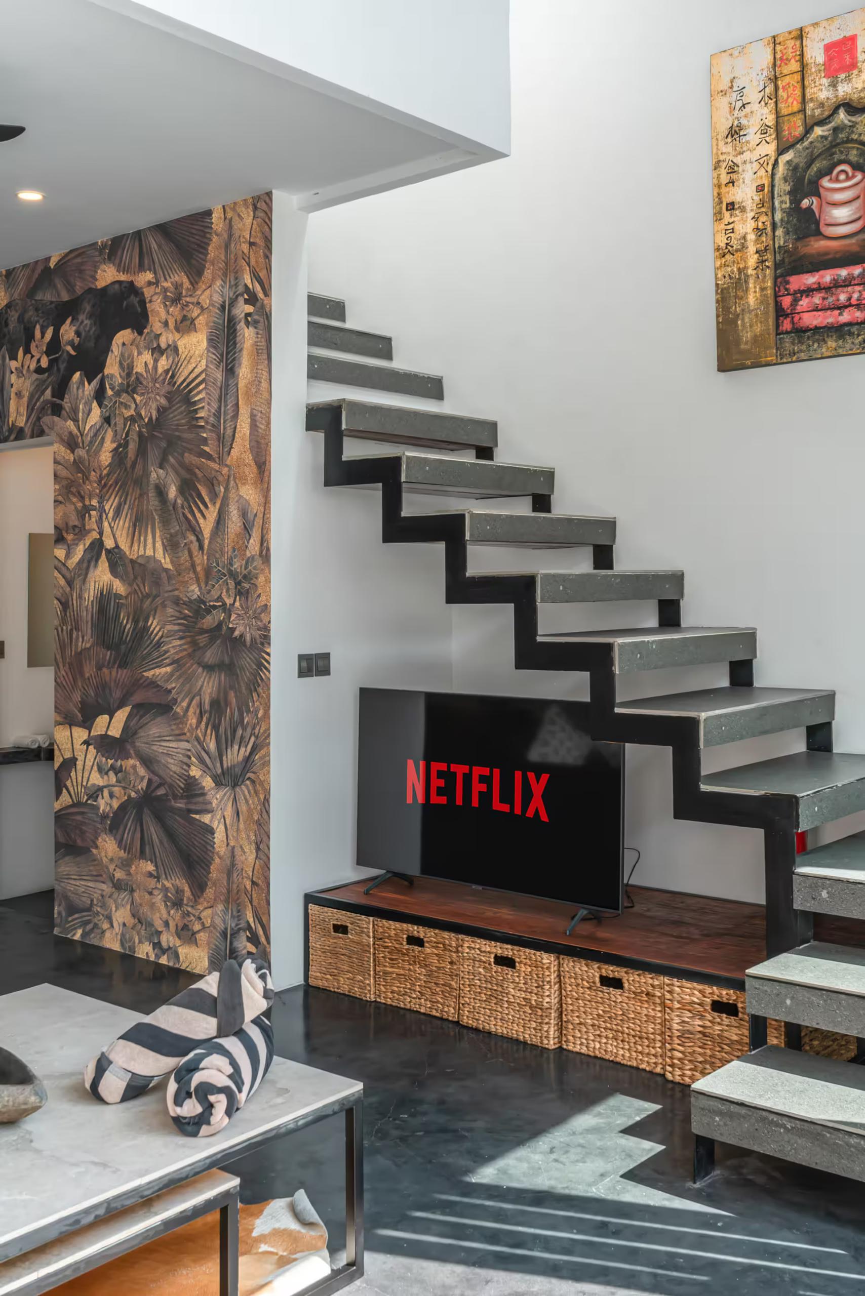 Floating concrete treads climbing beside a sepia botanical mural and the screen