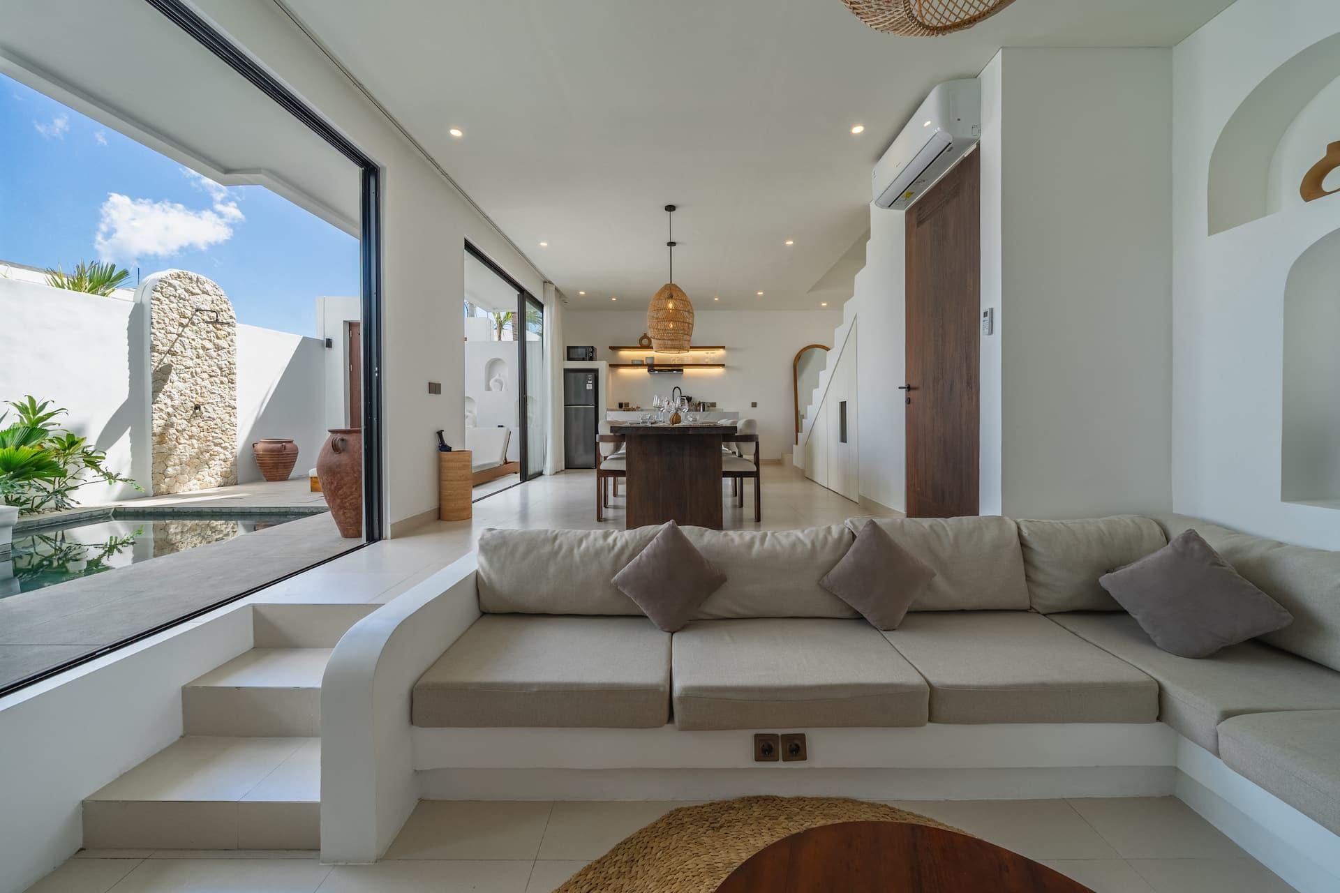 The open-plan living room of Nova Oasis Berawa 2 looking straight out to the pool through full-height sliding glass