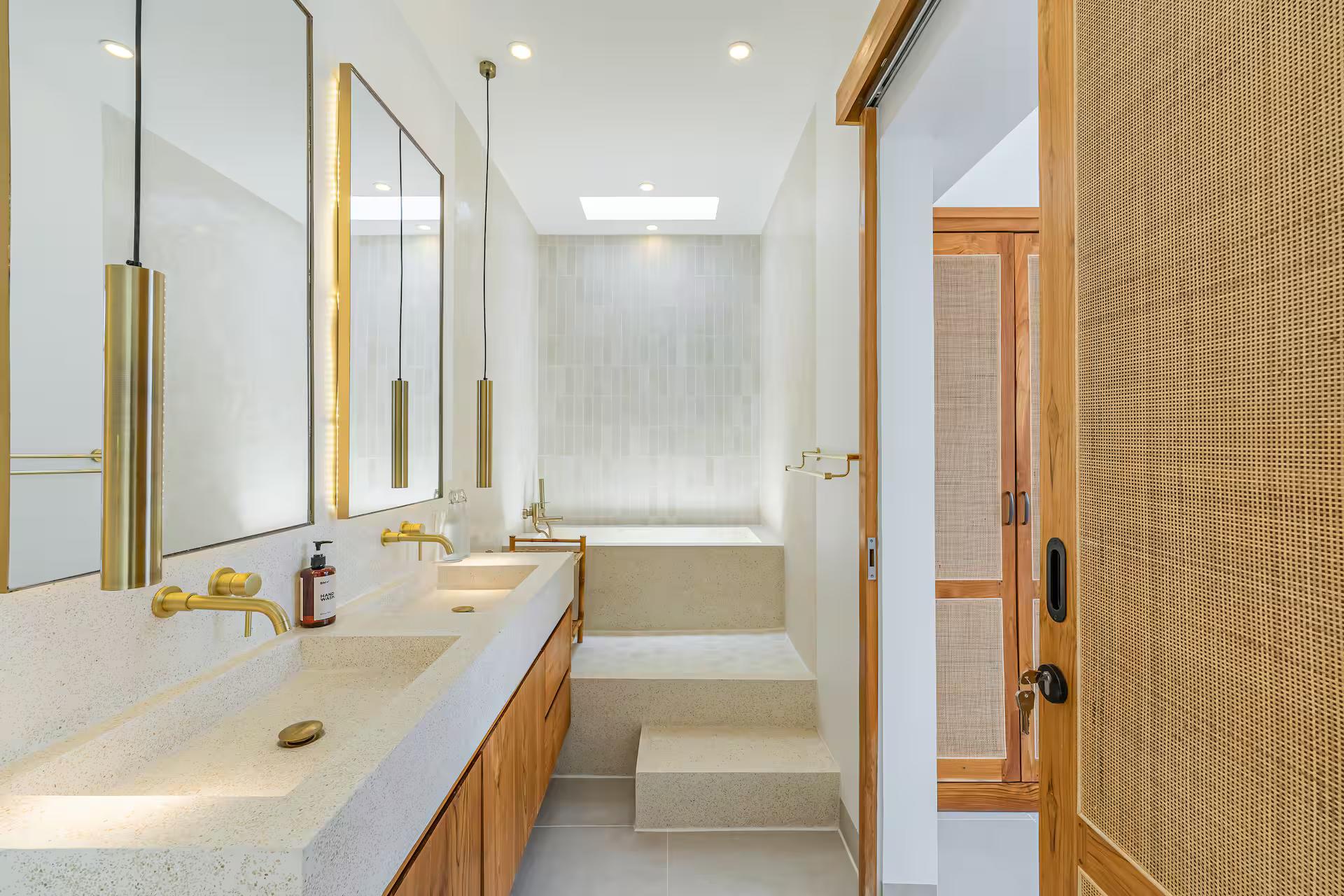 Terrazzo trough vanity with brass tapware and a step up to the deep soaking tub