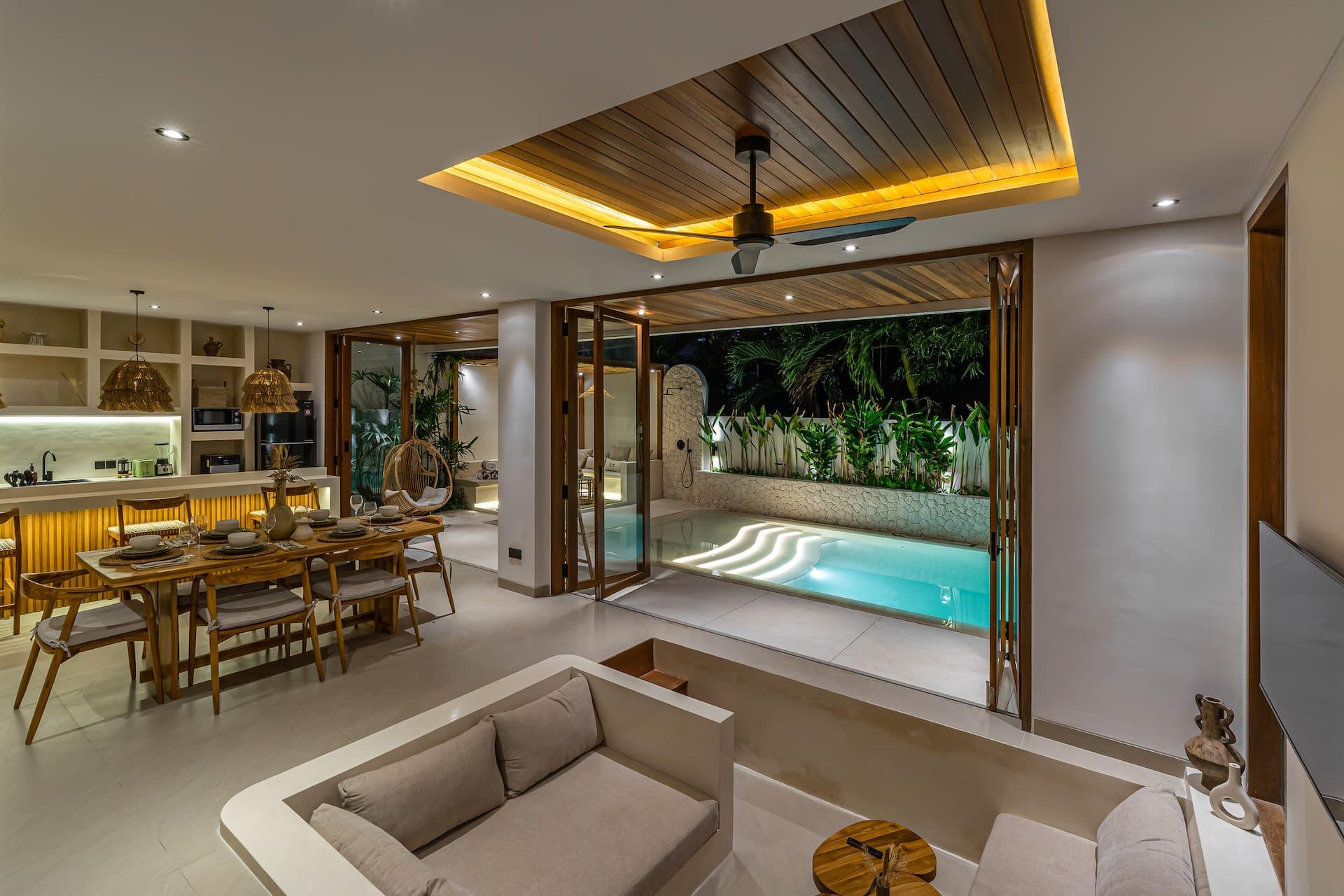 The open-plan living room of Villa Paraiso looking through folding doors to the water