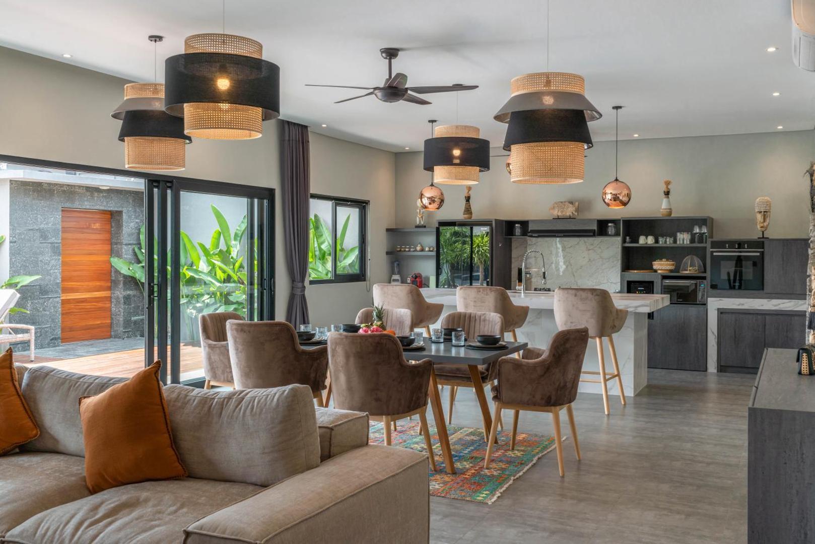 Open-plan living, dining and kitchen at Villa Koya with glass sliding onto the deck