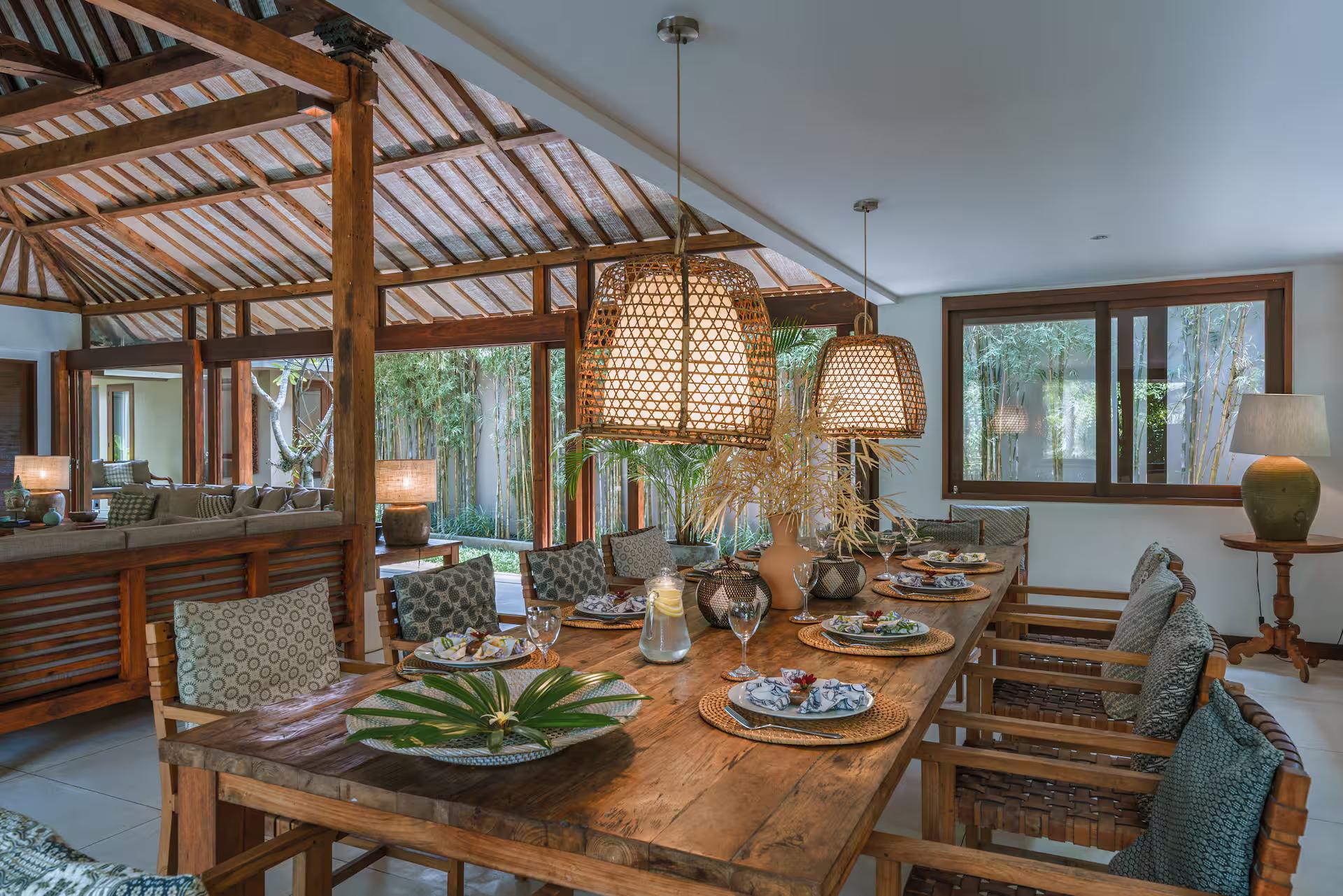 Dining table laid under woven pendants in the open pavilion at Villa Amore