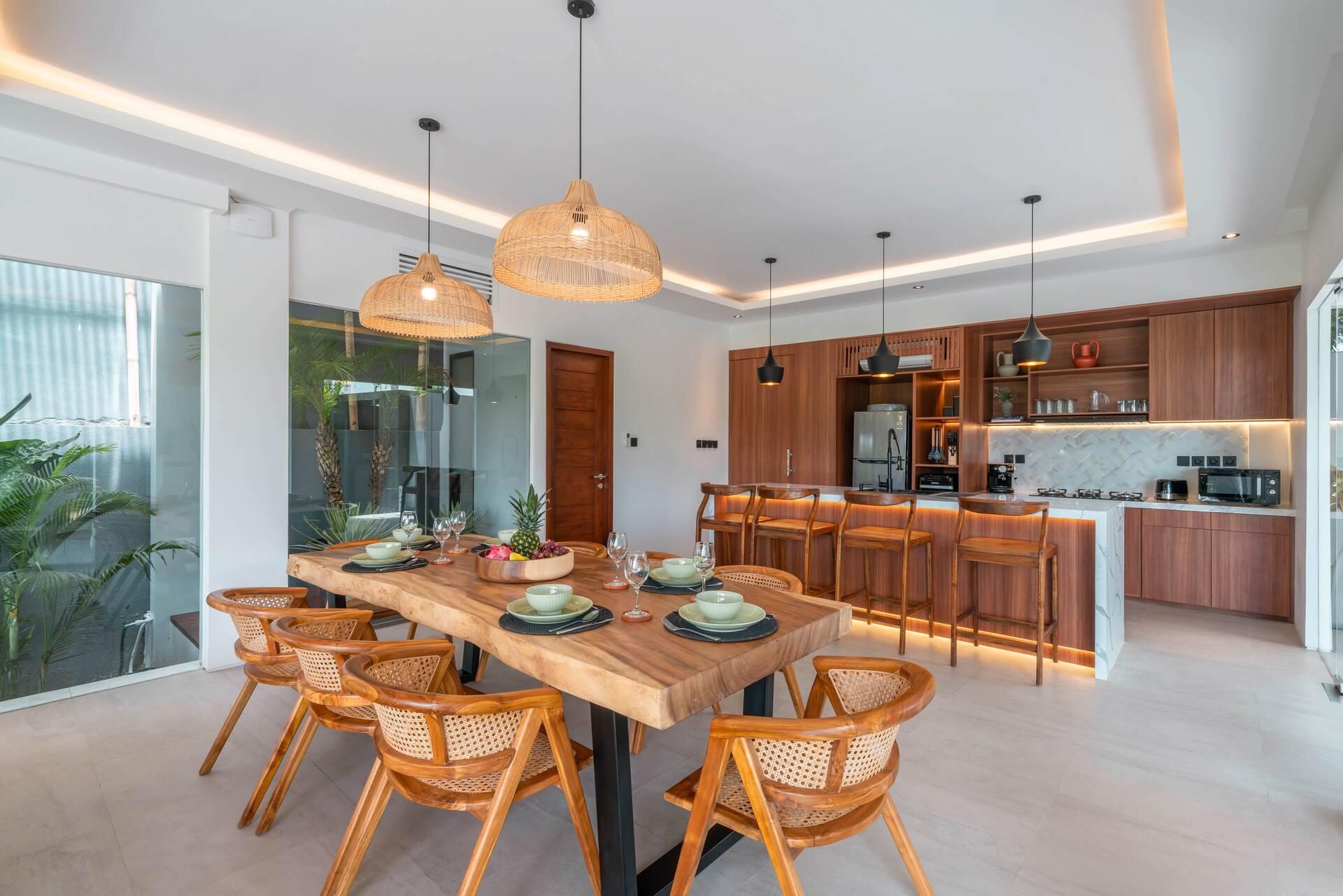 Live-edge dining table for eight in rattan chairs under three woven pendant lights