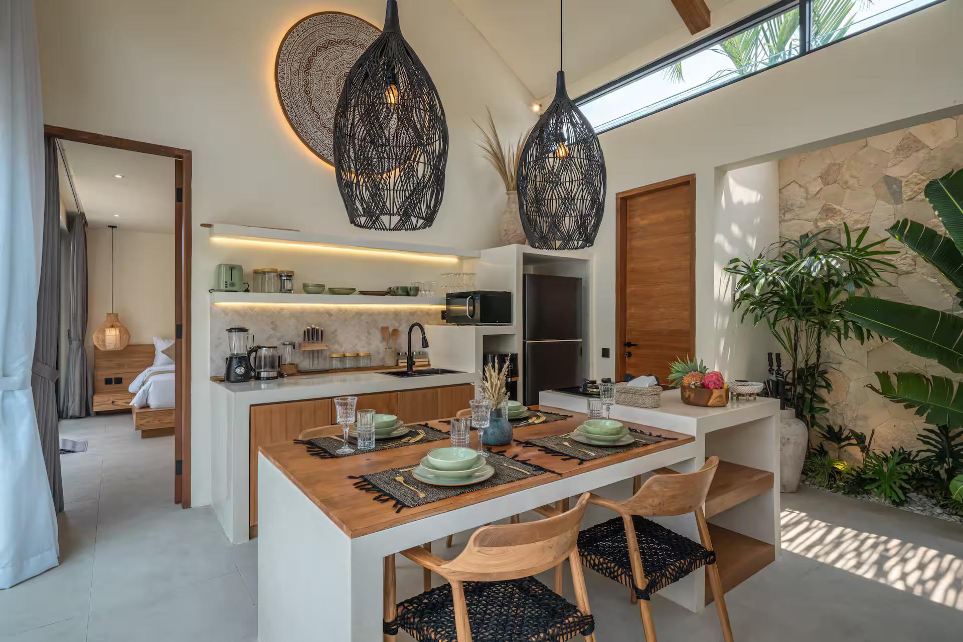 Kitchen island in white render with a timber top and woven-seat chairs