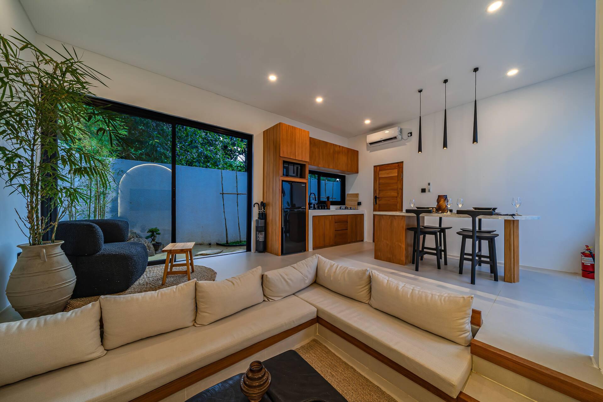 Open living and kitchen at Villa Nara, sunken seating facing the timber galley beyond