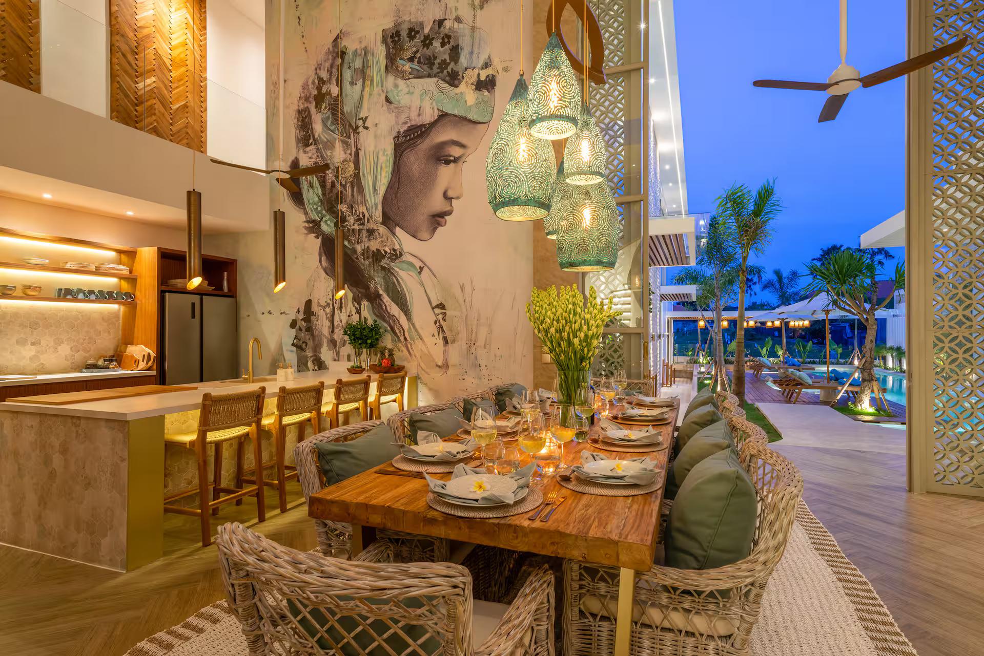 Kitchen and dining at dusk beneath a painted mural of a woman's face