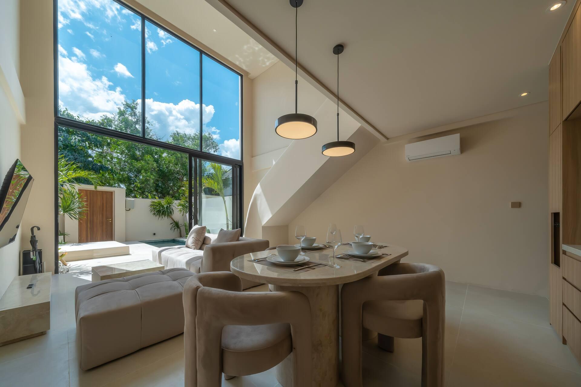 The dining table at Enso 4 sits beside a tall window looking into the garden