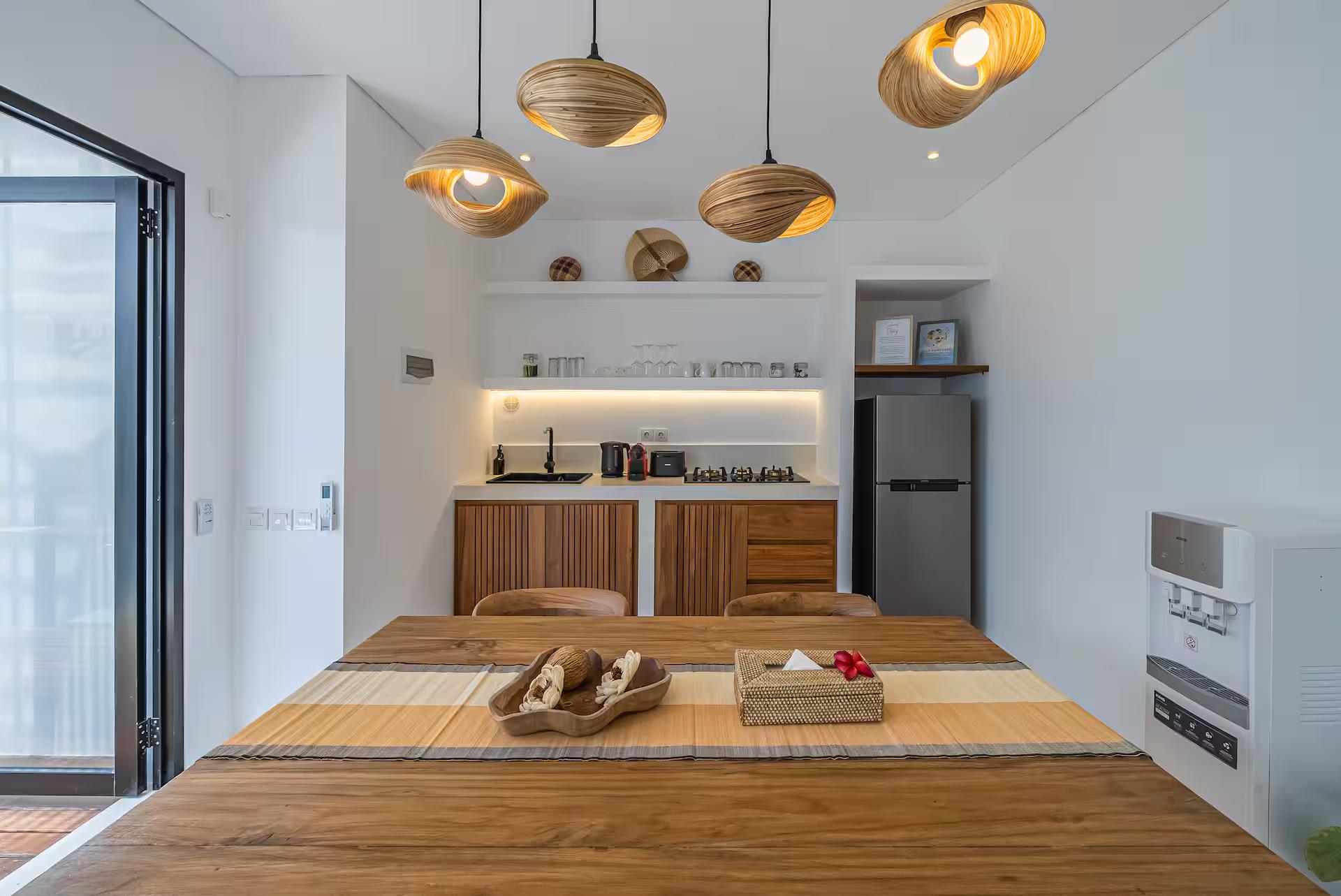 Kitchen along the back wall of the open-plan floor, timber joinery and a black stone counter