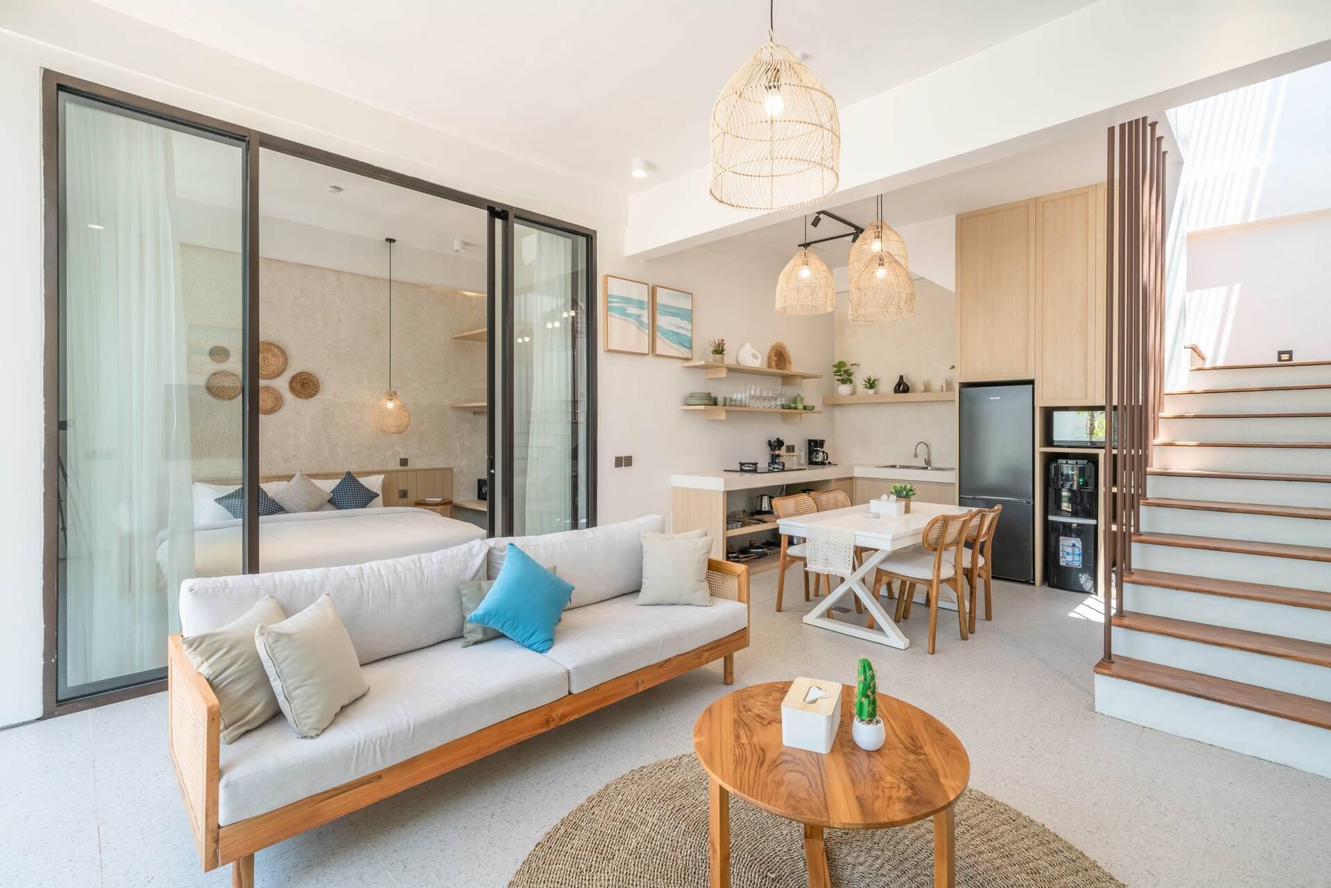 Low pale sofa and round timber table at Casa Sirena, facing the glass wall onto the courtyard