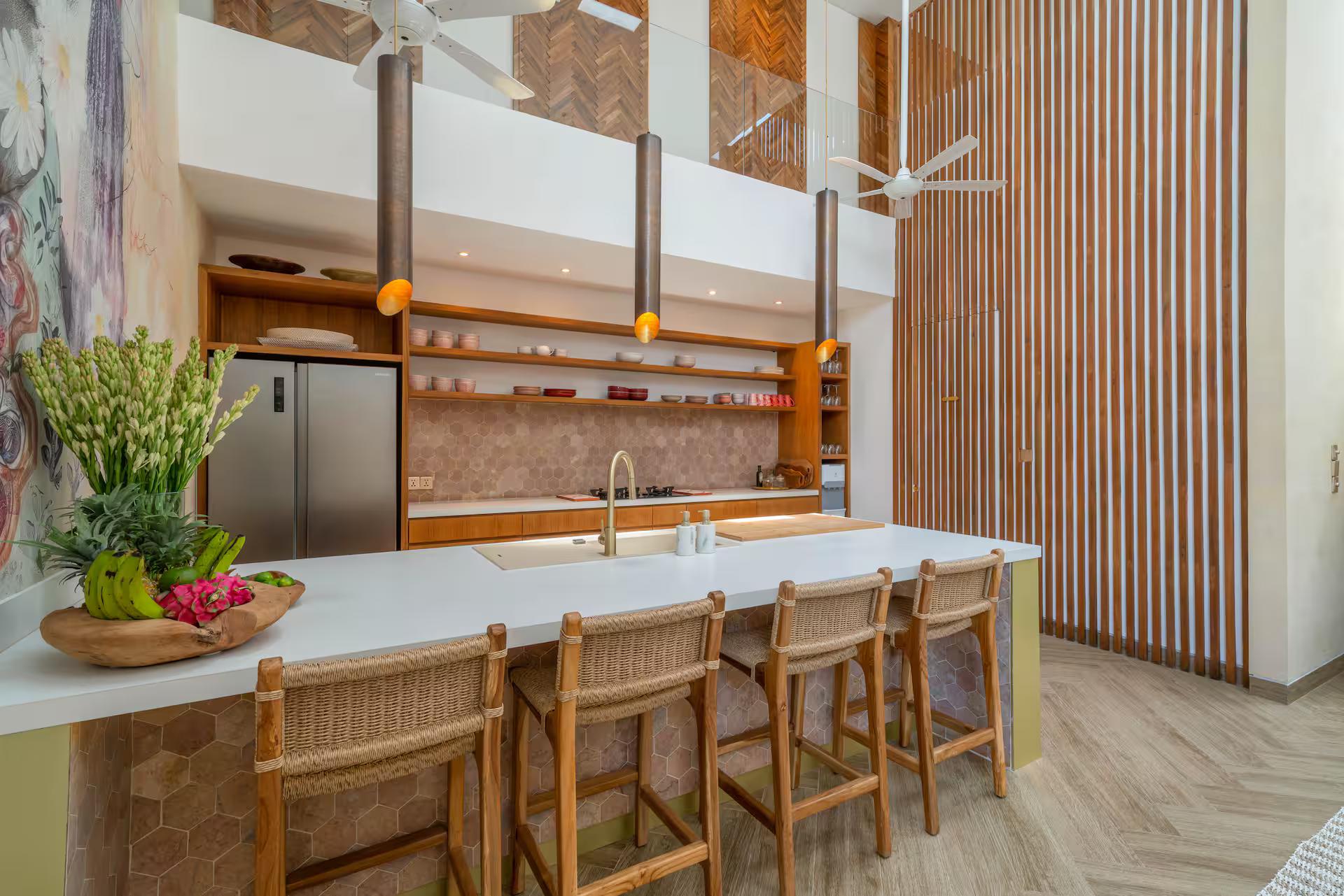 Kitchen island in stone and timber at Villa Vida & Vola, bar stools along one side