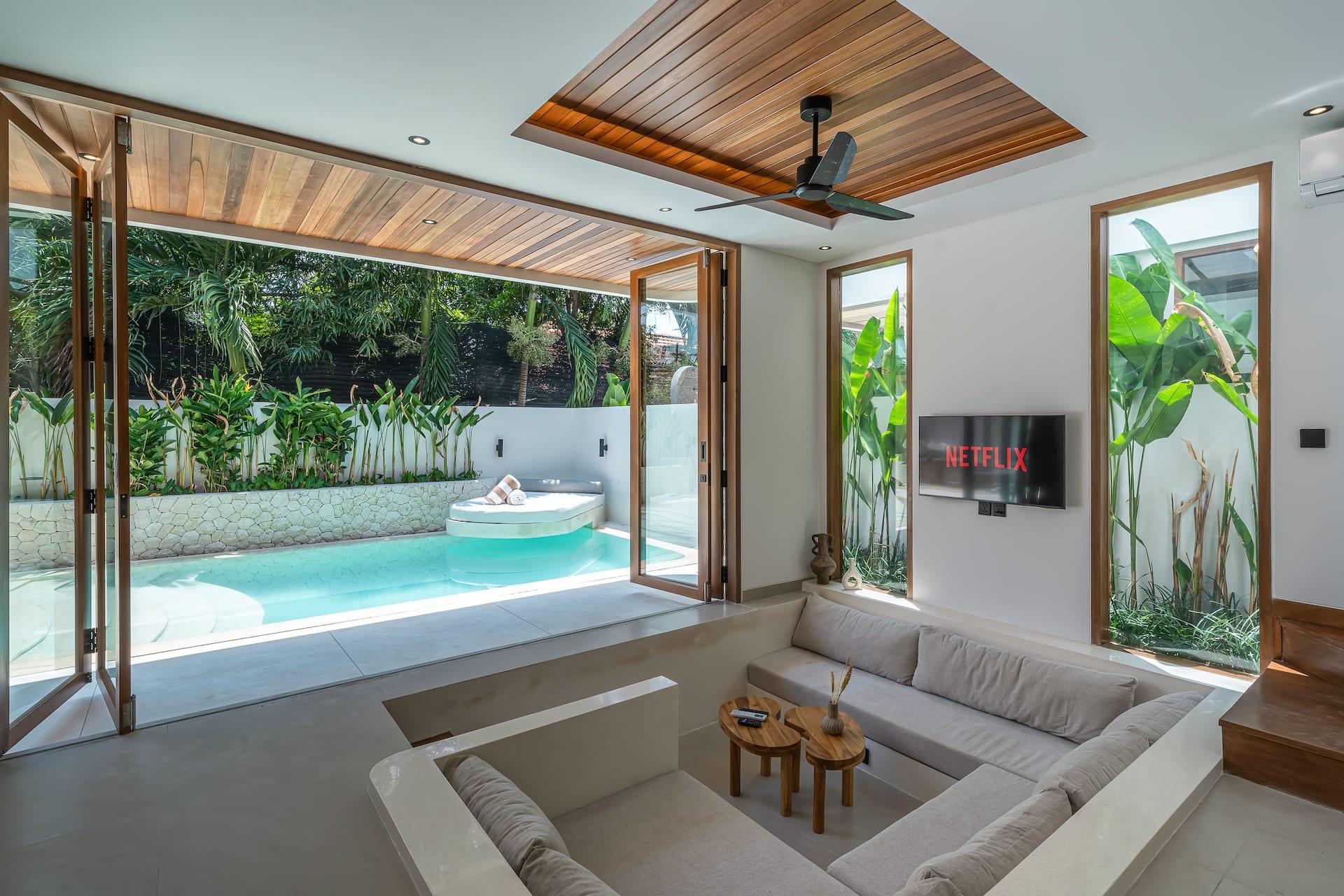 Timber-framed doors fold back on both sides of the living room, leaving it open to the garden