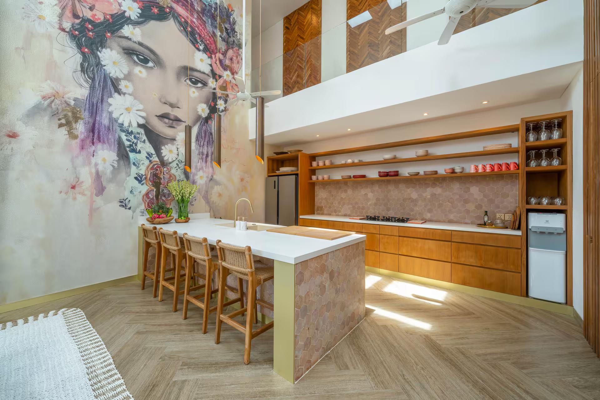Kitchen island and bar stools set against the painted mural wall at Villa Vida