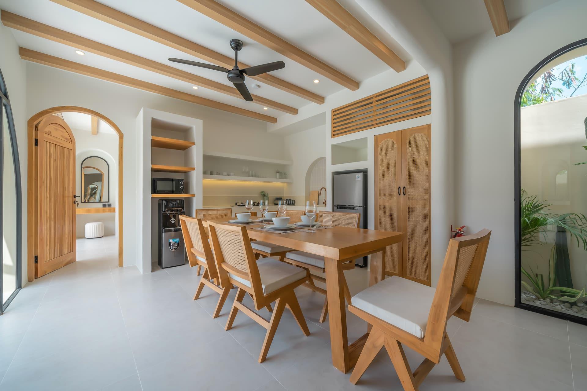 Dining and kitchen at Villa Sorrento under the ribbed timber ceiling, arched doorways on every side