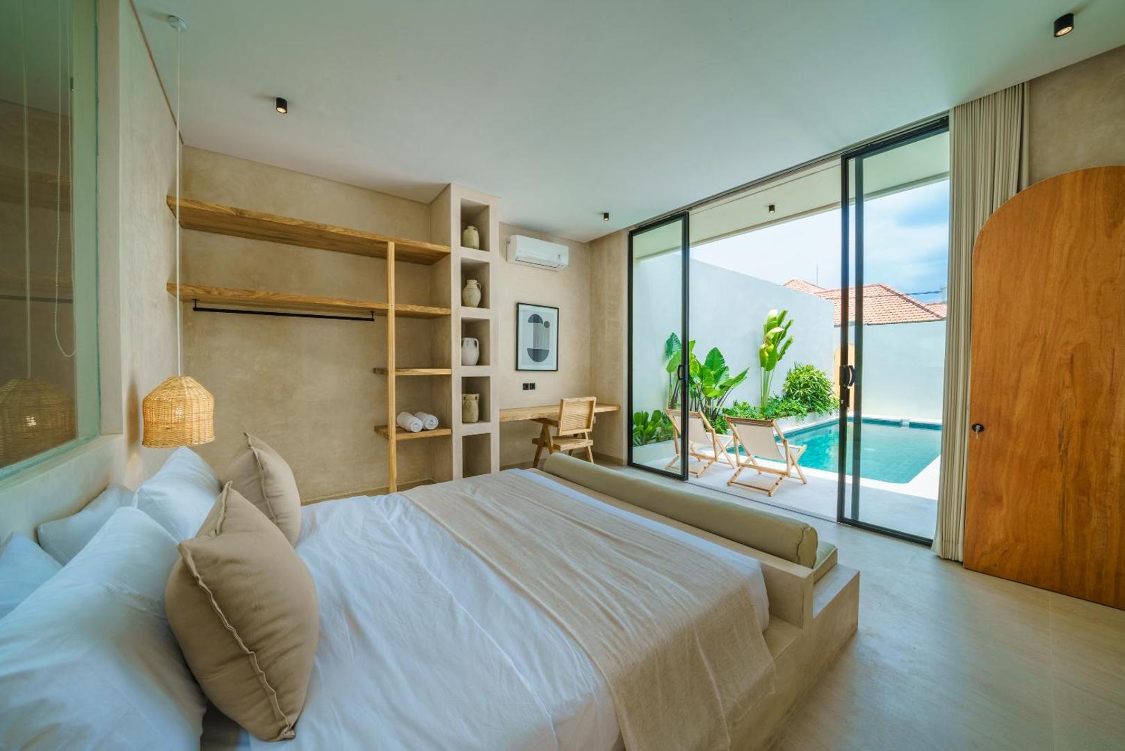 Second king bedroom at Villa Leros, timber shelving beside a glass door onto the pool terrace
