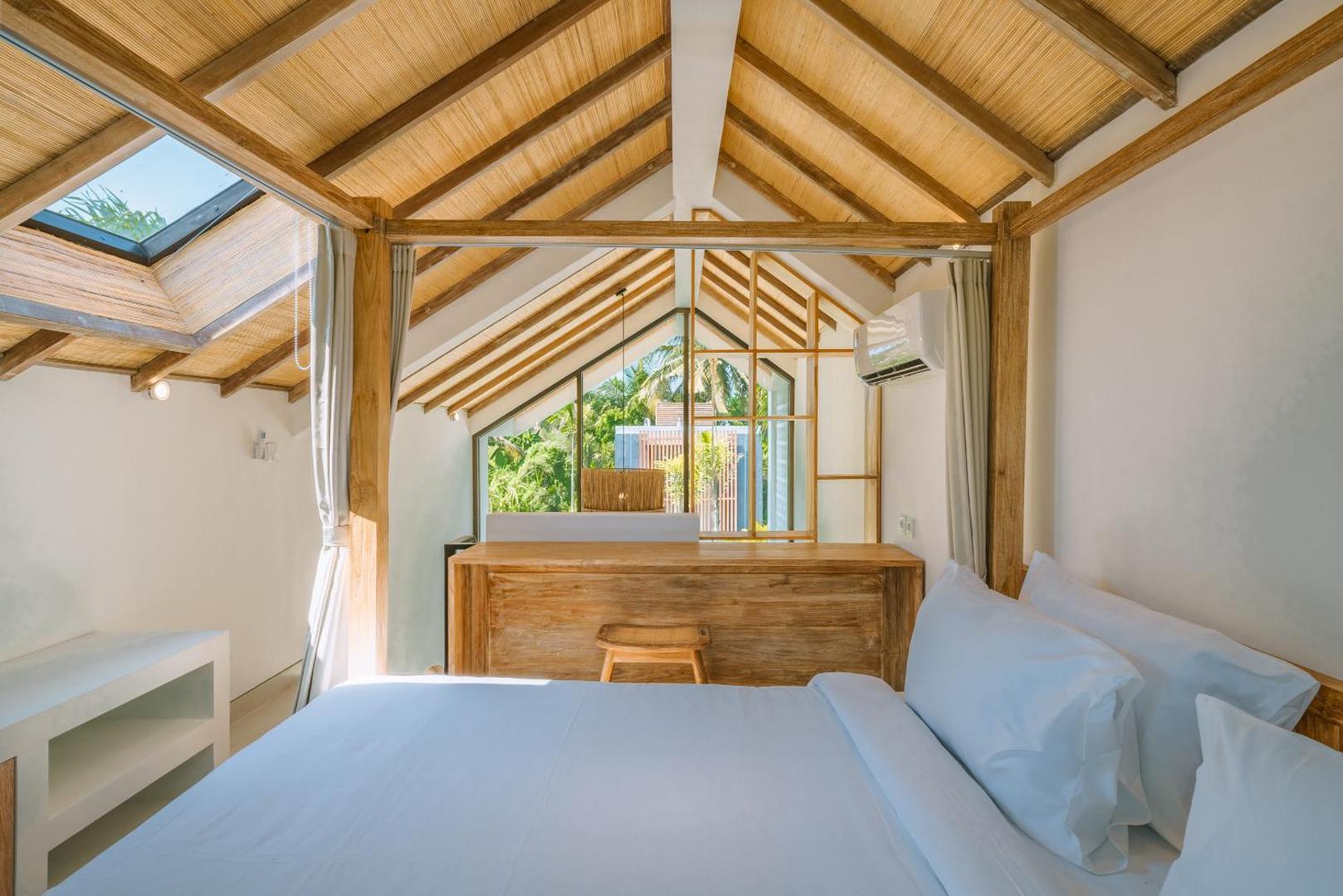 The mezzanine bed beneath the timber rafters, skylight and full-height gable window