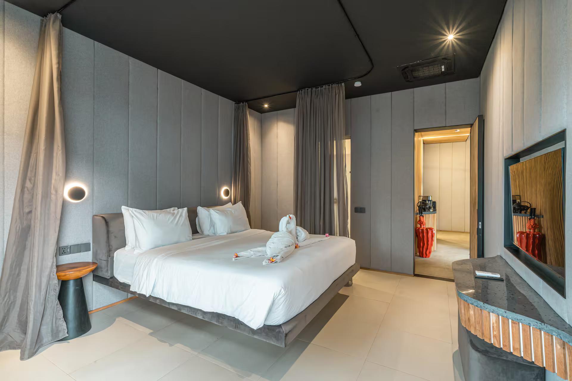 King bedroom in grey panelling with sheer curtains hung on a ceiling track