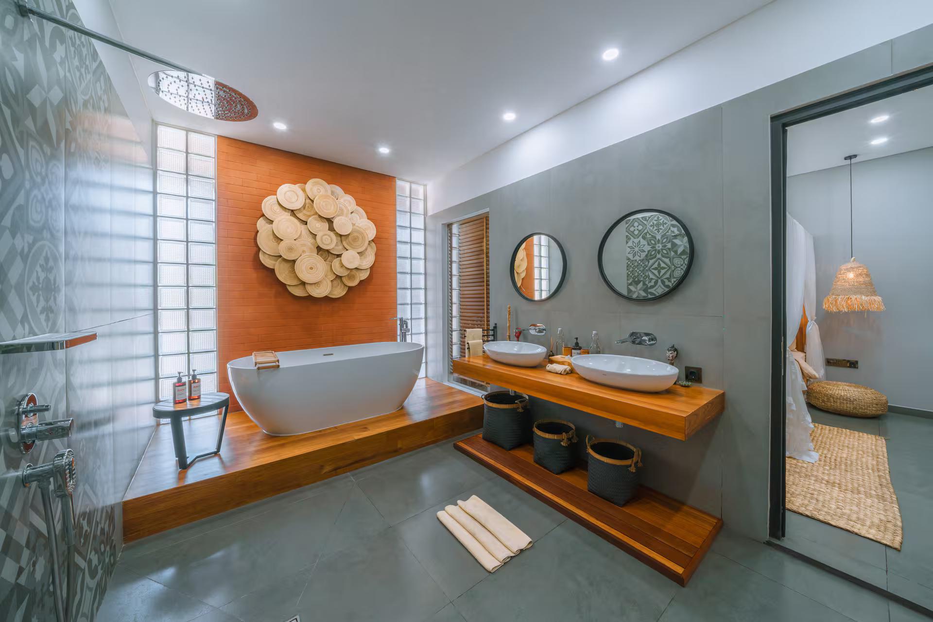 Freestanding tub on a timber platform below a raffia sunburst on burnt-orange render