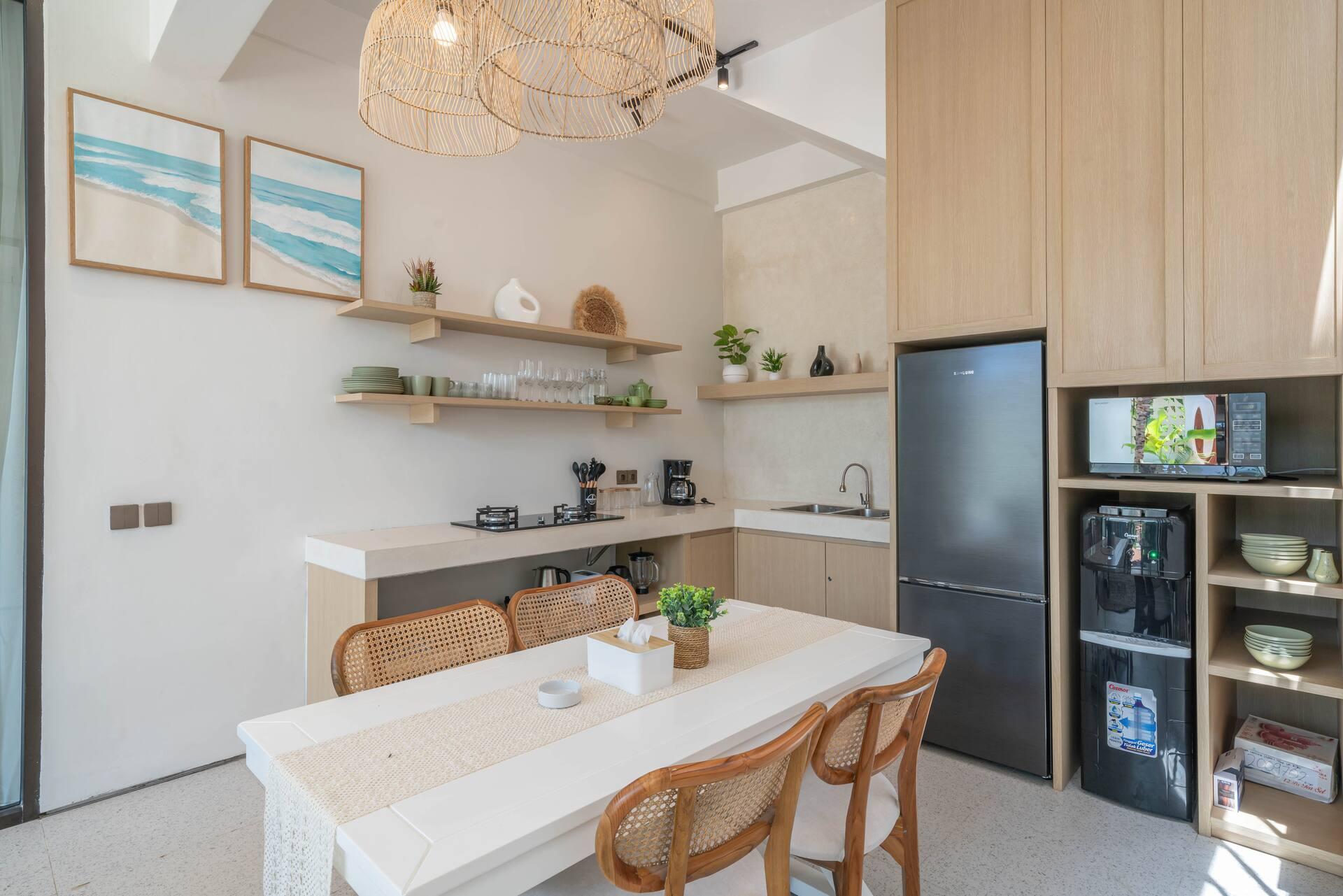Trestle dining table and rattan chairs beside the kitchen's open timber shelving