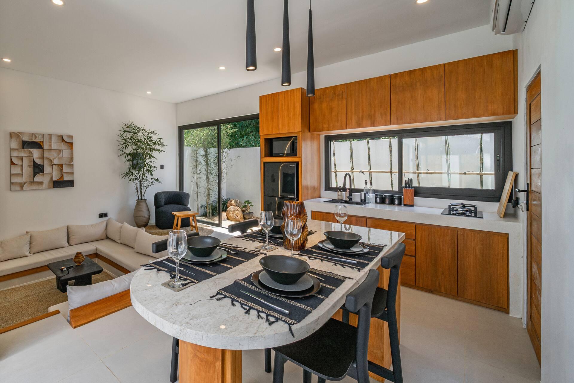 Timber kitchen with integrated oven and stone counters beside the dining table