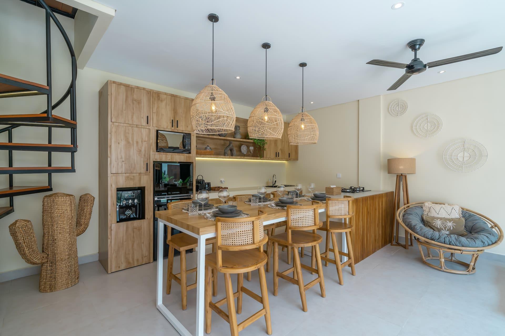 Open kitchen and breakfast bar with rattan stools, the spiral staircase alongside