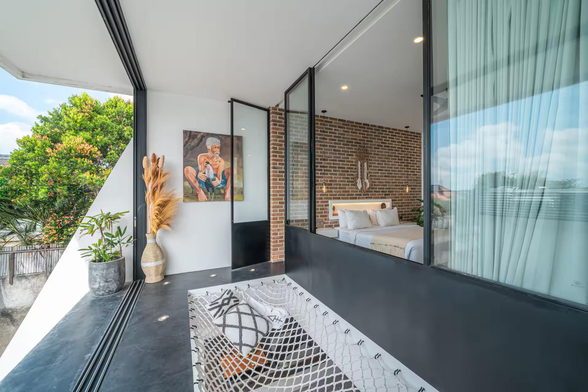 Upstairs landing with the hammock net and the bedroom glass, palms beyond the terrace